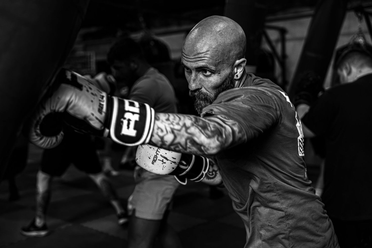 A series of mixed martial arts fighters exchange punches and grapple during intense combat matches in black and white.