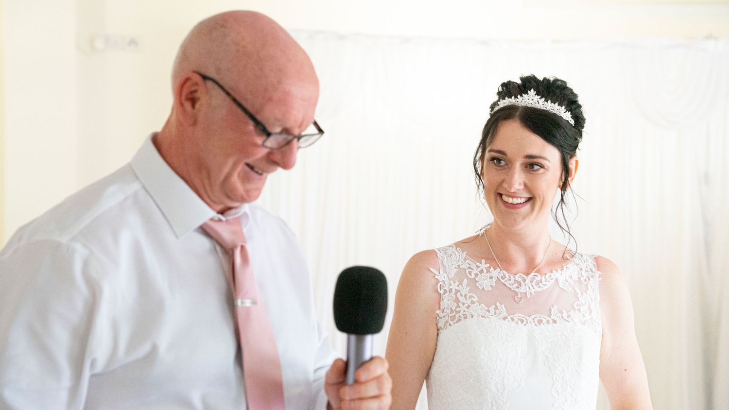 Indoor wedding ceremony moments with white backdrop and emotional expressions.