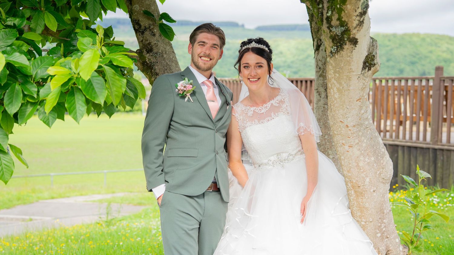 A scenic wedding day photoshoot showing newlyweds walking and posing at a rustic barn venue surrounded by lush greenery.