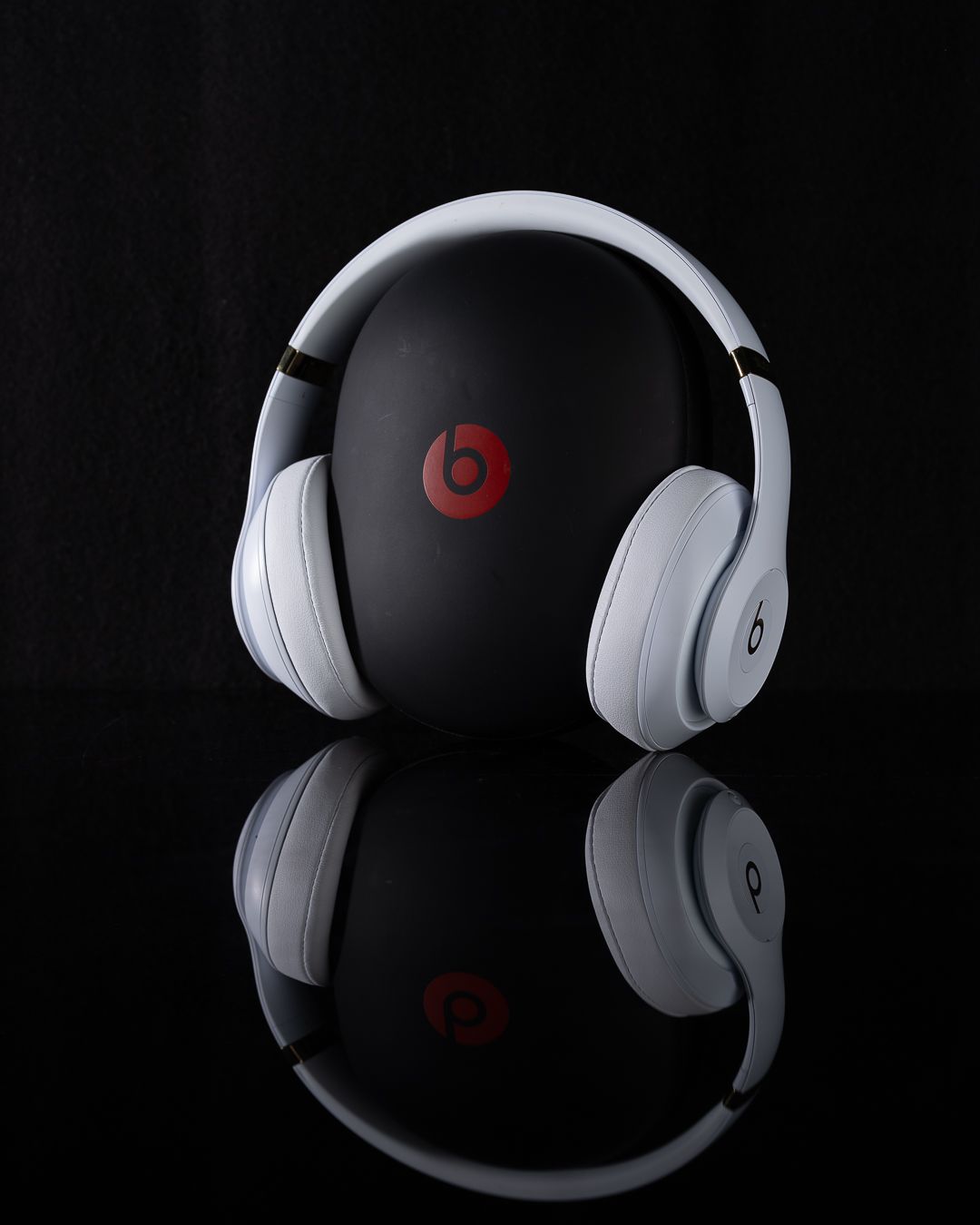 White and red Beats headphones shown from multiple angles against dark backgrounds in a product photography collage.