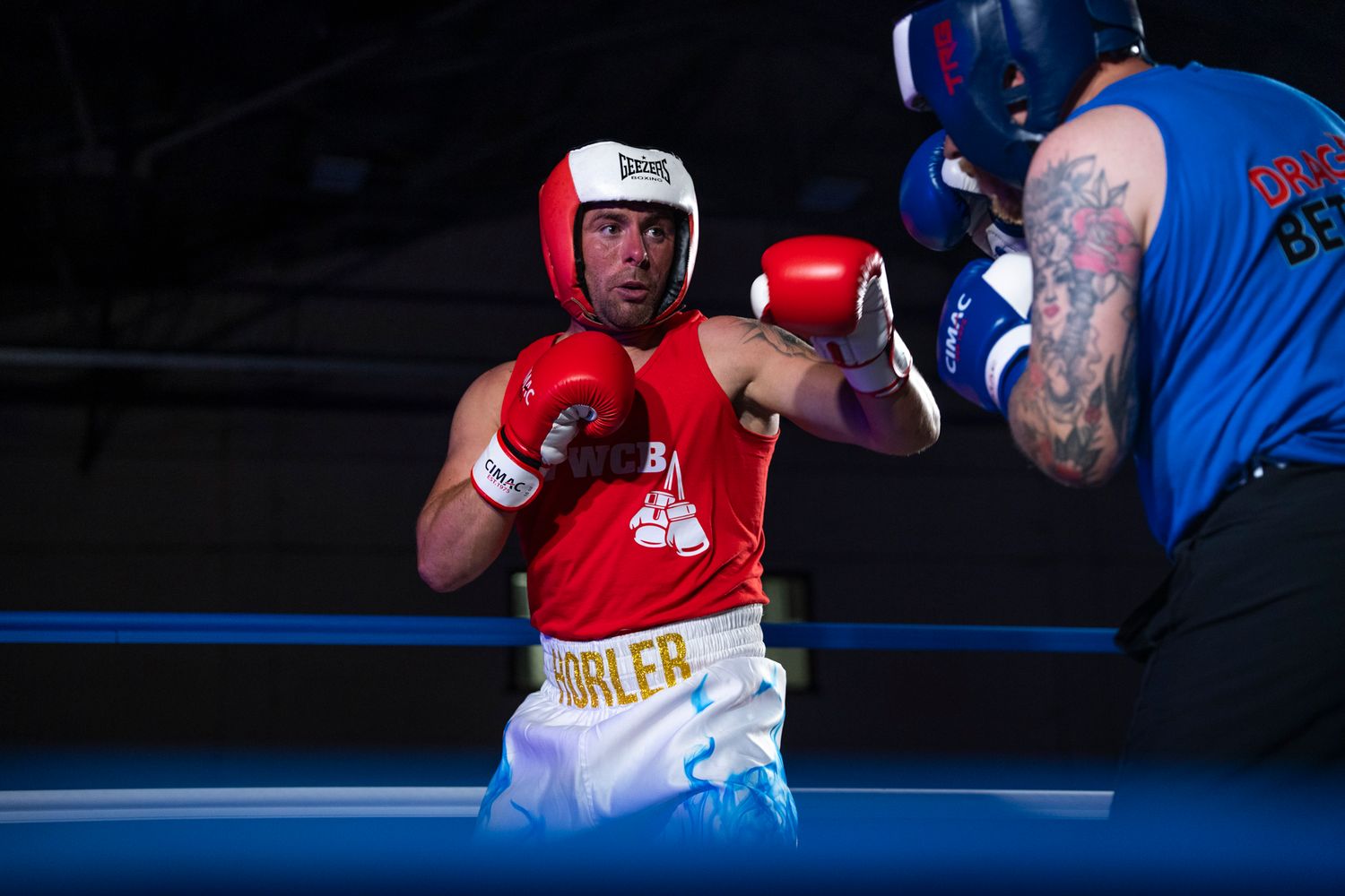 Two boxers exchange punches during an intense sparring match in a boxing ring.