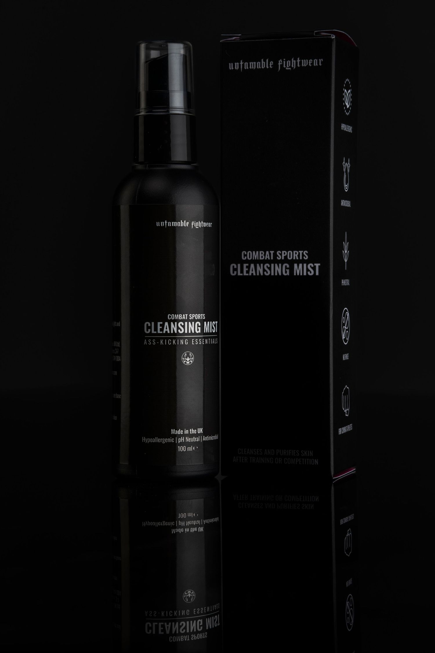 Dark product photography of luxury skincare cleansing mist bottles against black background.