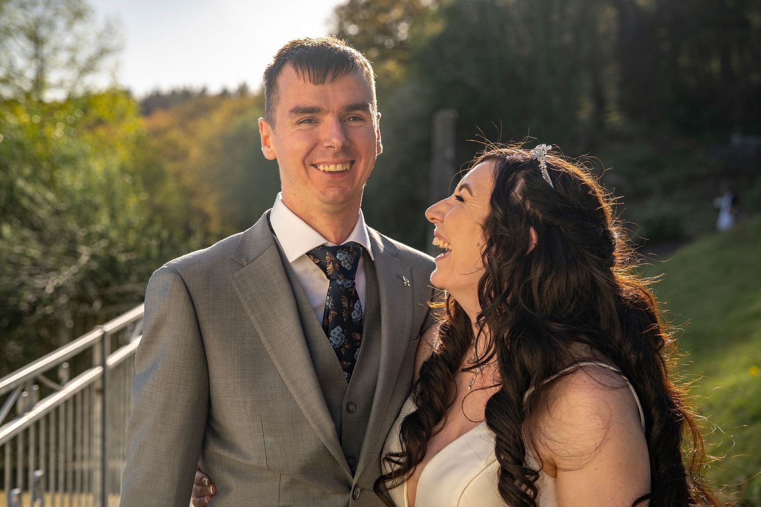 Happy couple sharing romantic moments outdoors during their autumn wedding celebration.