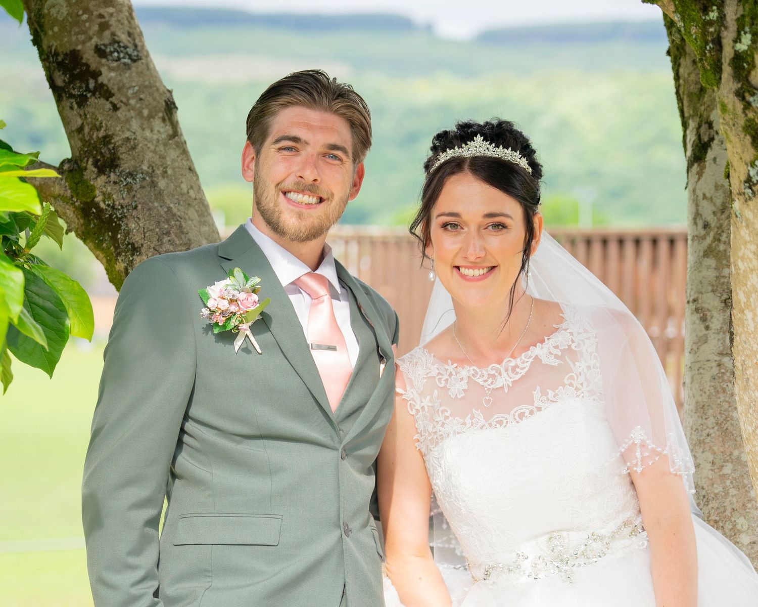 Outdoor wedding portraits with couple posing under trees in a garden setting.
