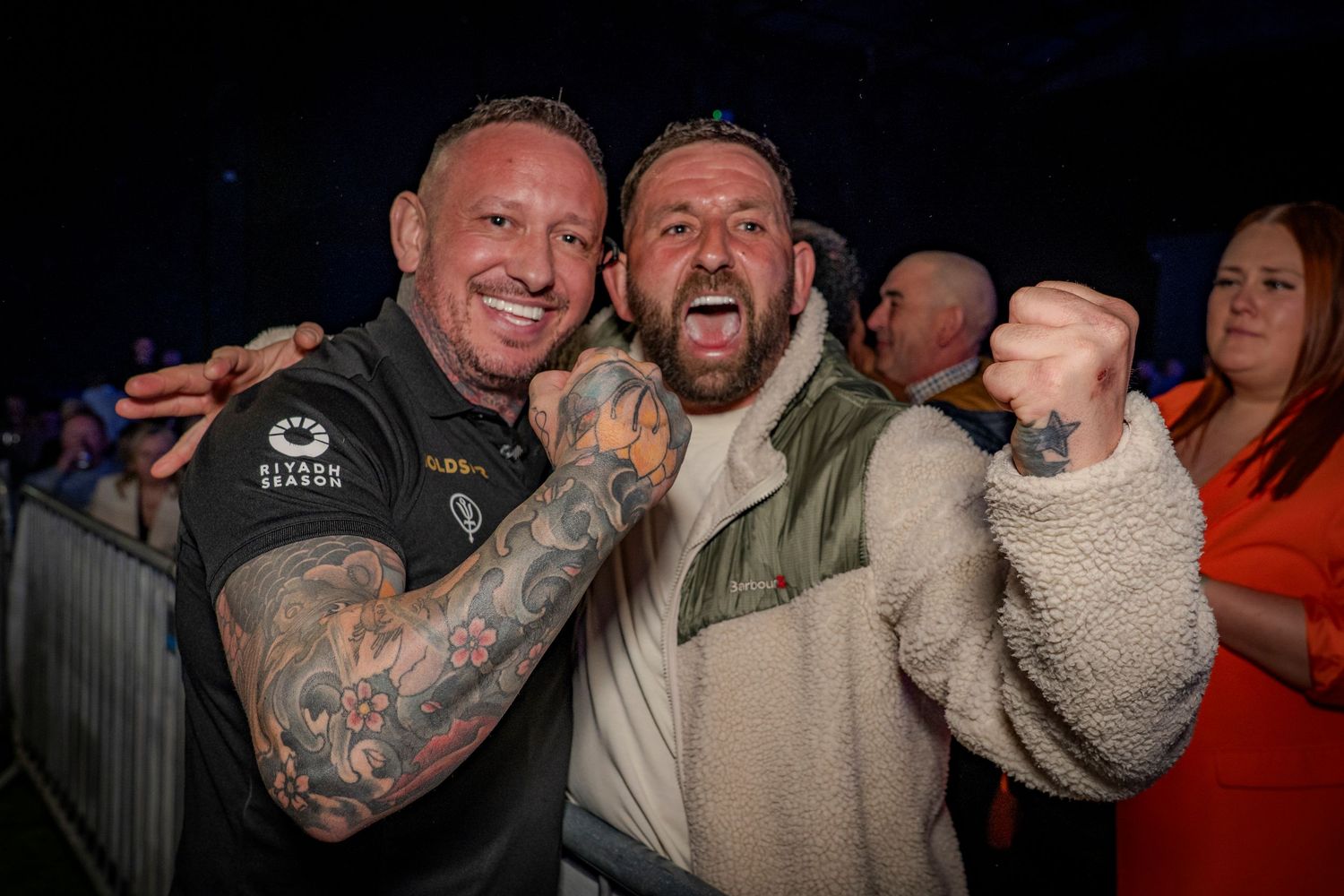Mixed martial arts fighters celebrate enthusiastically after a match with emotional displays of joy and excitement.