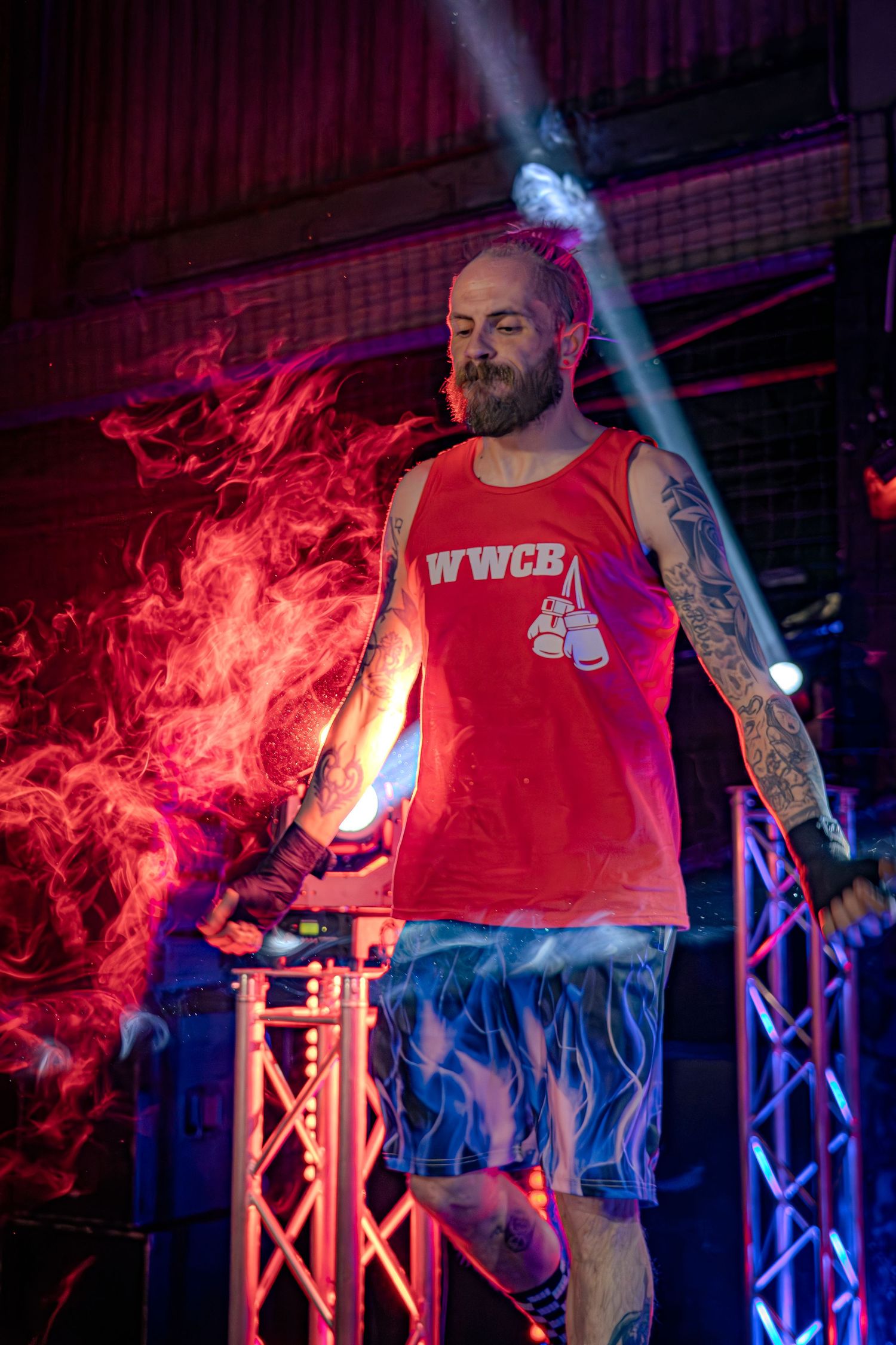Performance stage with dramatic red lighting and smoke effects.