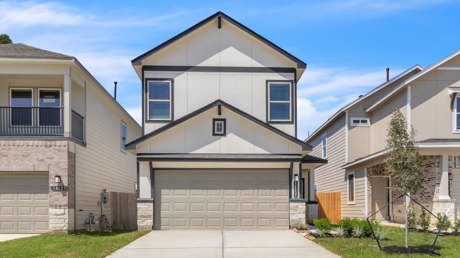 Modern two-story beige house with light trim and gray garage door in a residential neighborhood.