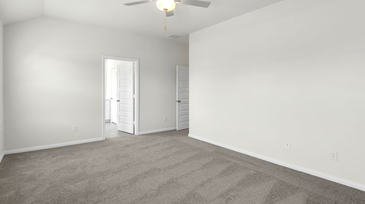 Interior view of empty white apartment rooms with ceiling fan and hardwood floors showing open floor plan layout.