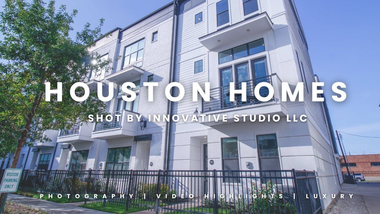 Modern white townhomes with black iron fencing in Houston featuring clean architectural lines and multi-story design.