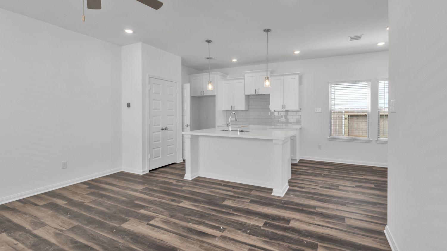 Modern commercial renovation project shows various angles of empty white rooms with new hardwood flooring and recessed lighting.
