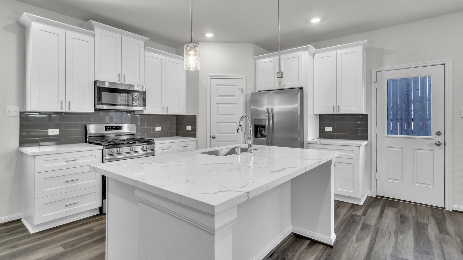 Panoramic view of a modern white kitchen featuring recessed lighting, stainless appliances and gray vinyl plank flooring.