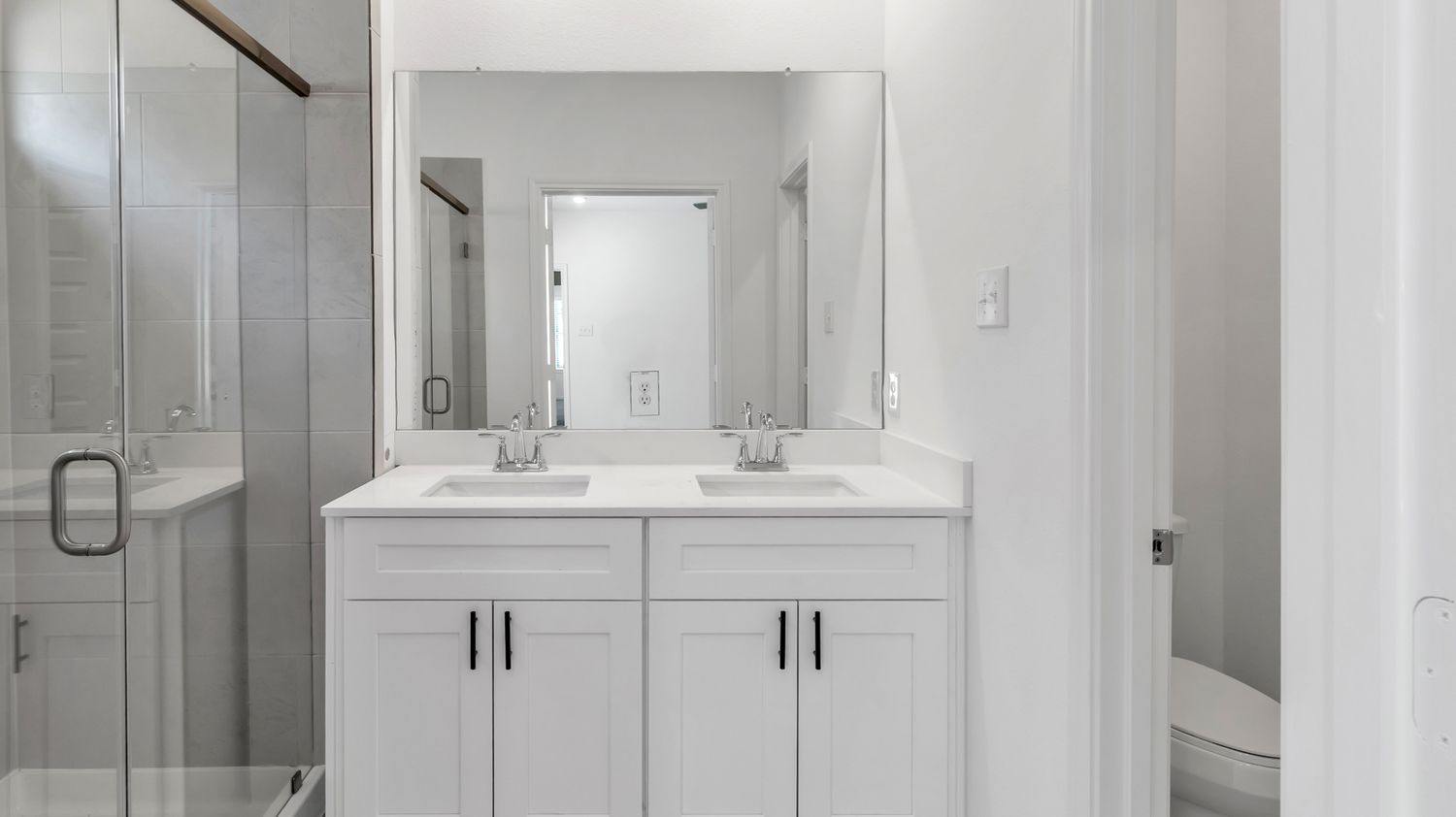 Modern white bathroom design features a walk-in shower, floating vanity, and sleek fixtures with monochromatic tiles.