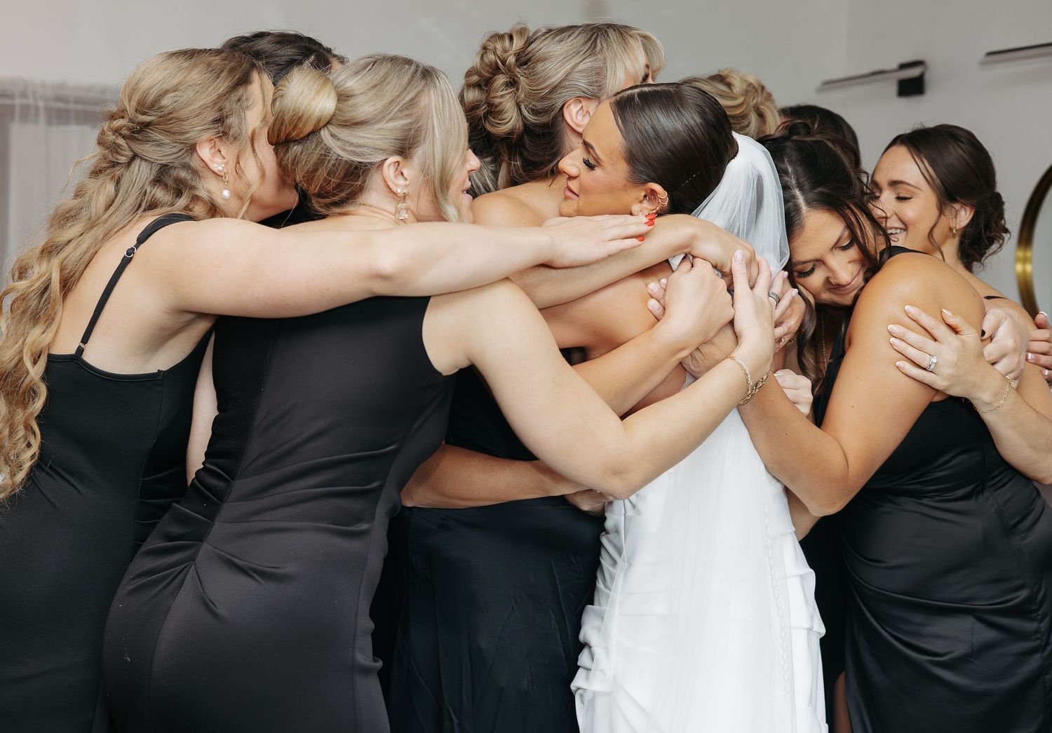 Bride and bridesmaid embracing an emotional hug