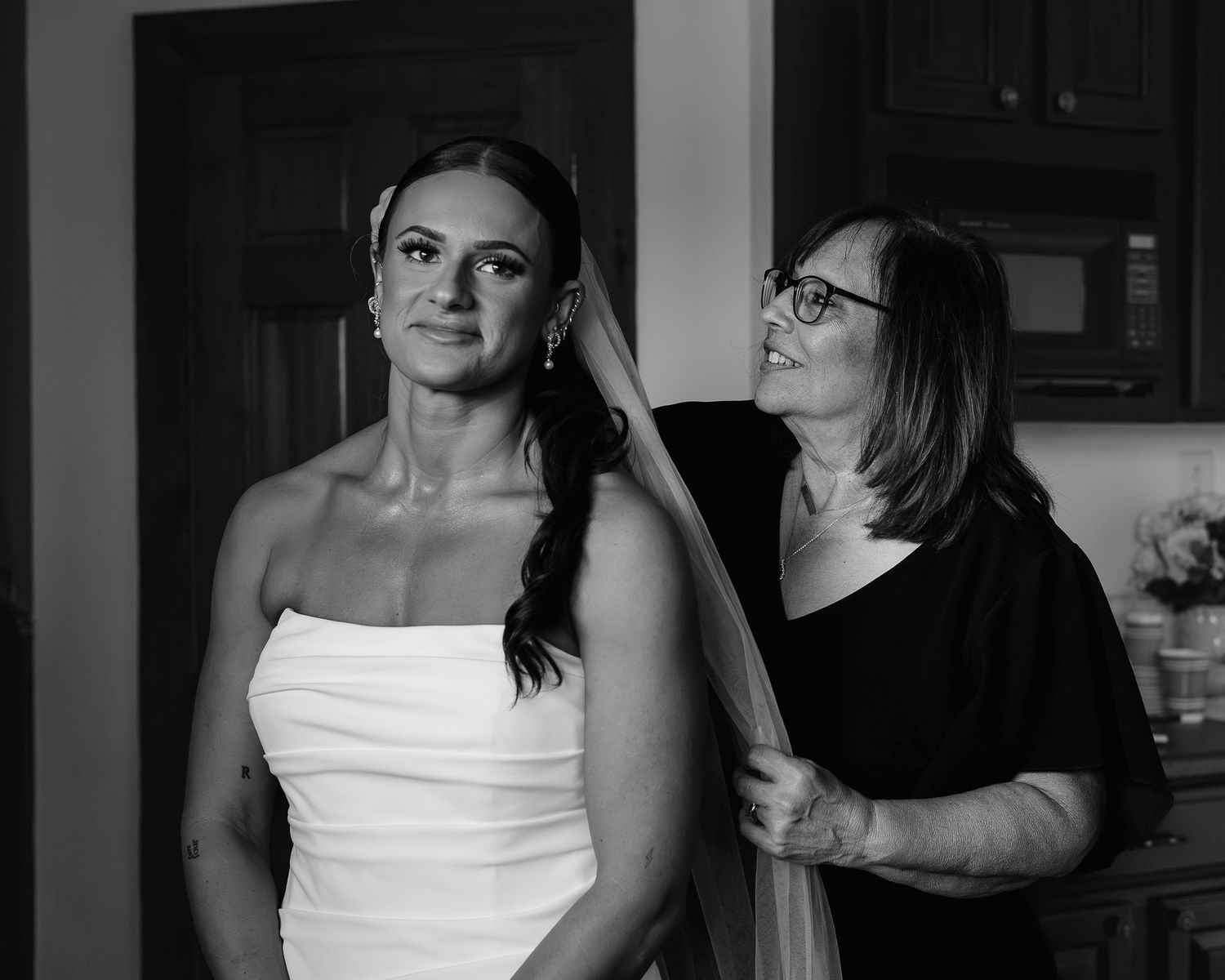 Mother helping bride with vail