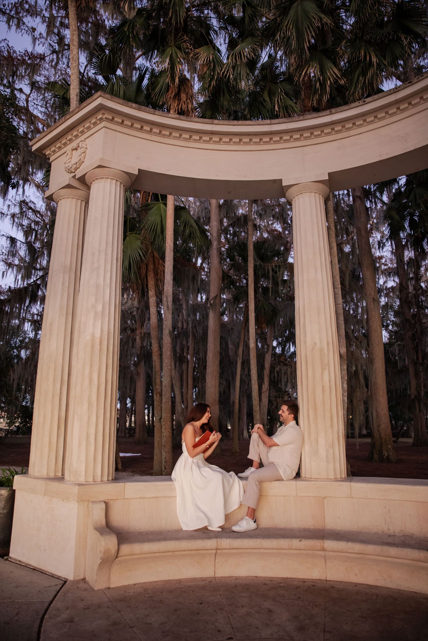 Couple laughing together during golden hour engagement session at Kraft Azalea Garden.