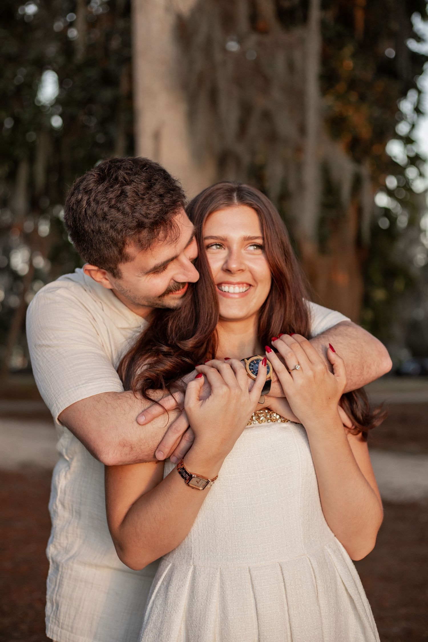 Couple laughing together during golden hour engagement session at Kraft Azalea Garden.