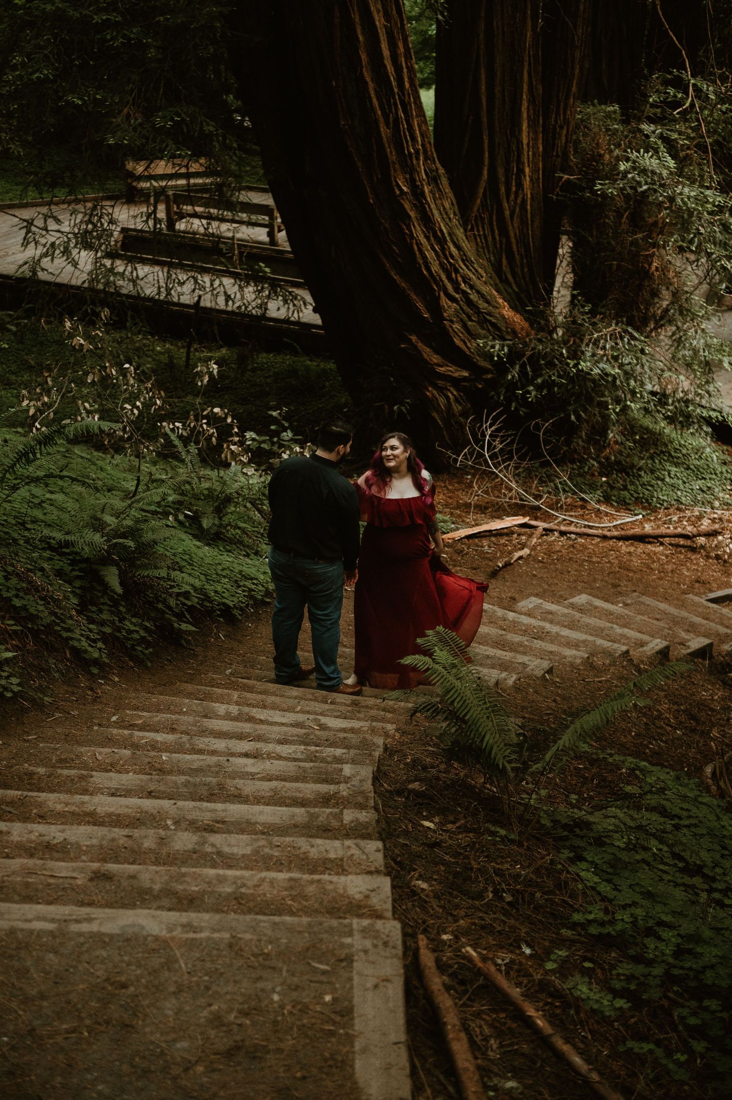 Stone steps winding through a forest with two people in the distance.