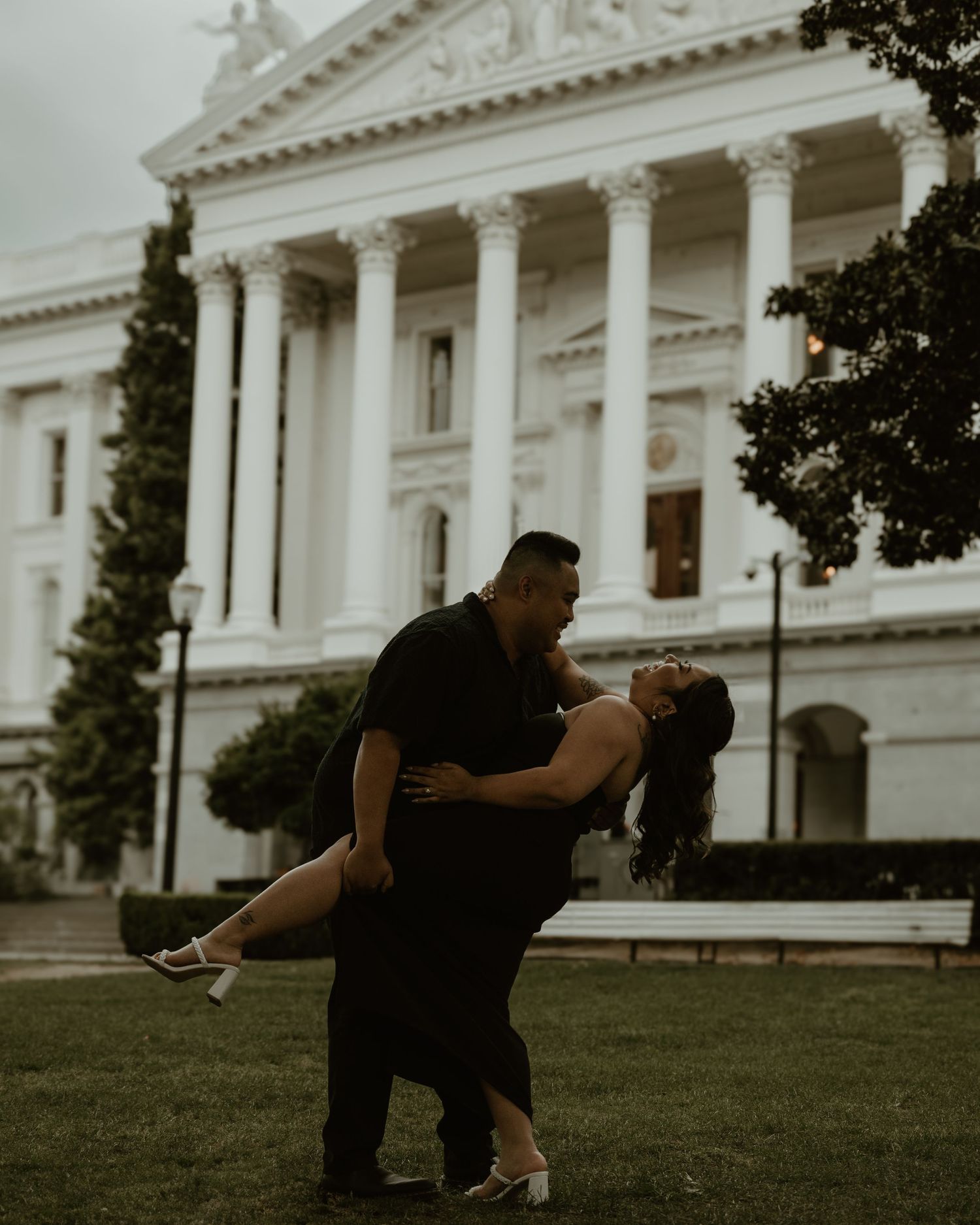 A dramatic dip pose in front of a grand neoclassical building with white columns.