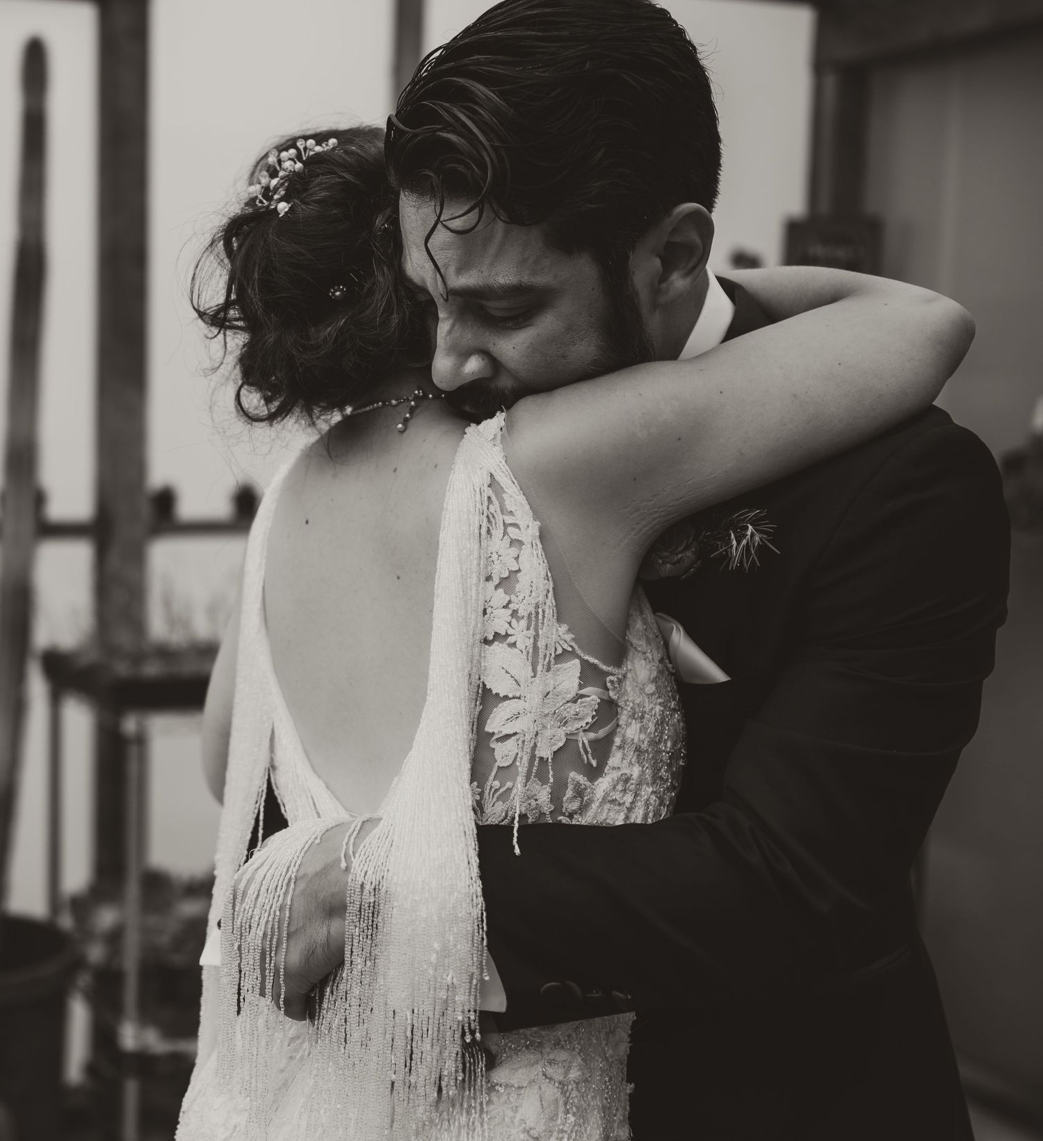 Black and white wedding photo captures intimate embrace between newlyweds.