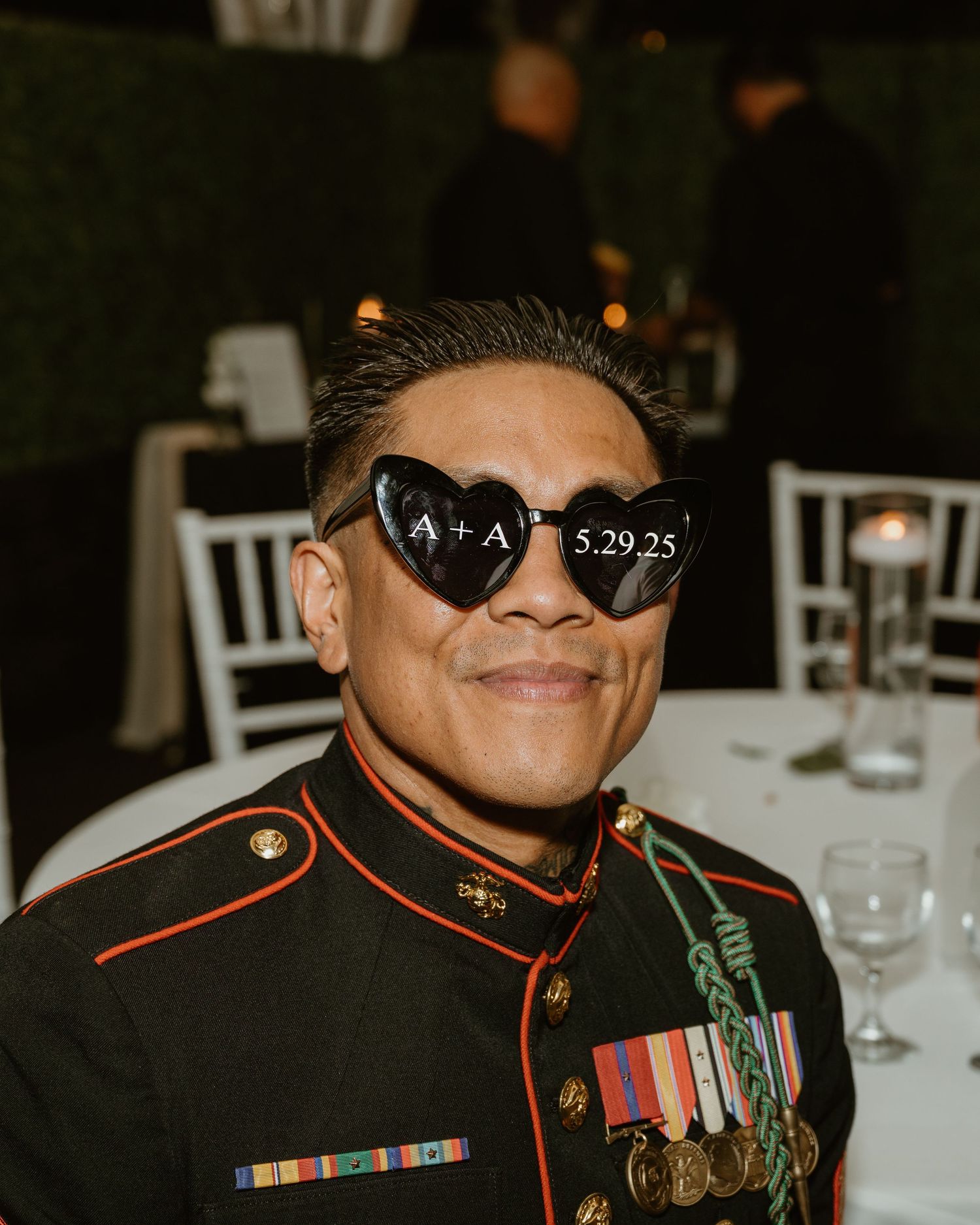 Marine in dress uniform wearing sunglasses at formal wedding reception.