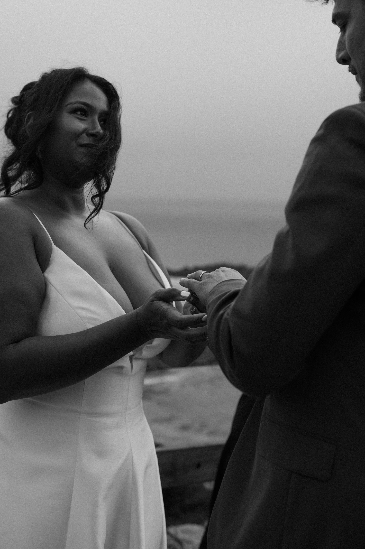 A tender black and white wedding moment captured outdoors during a romantic ceremony.