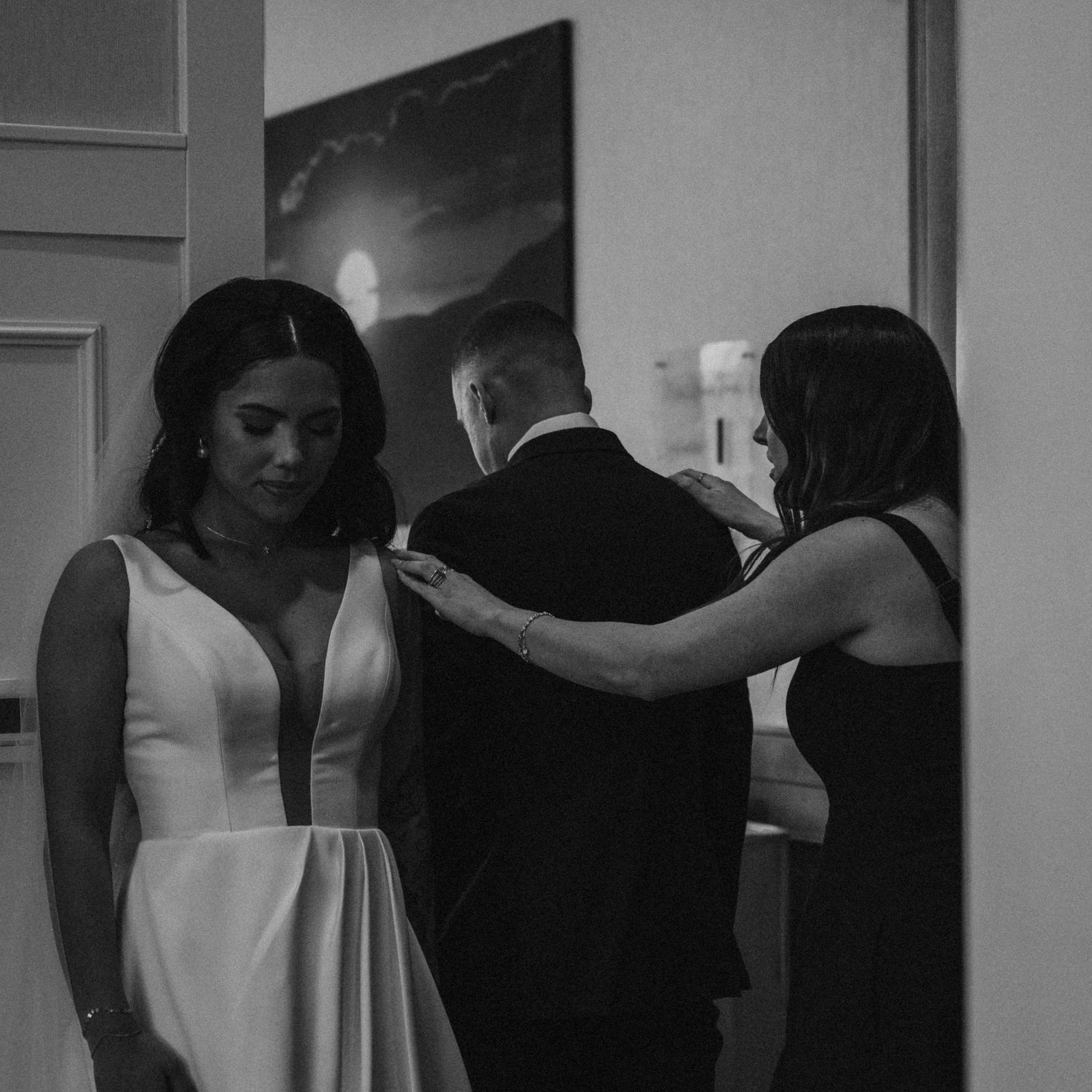 A wedding party getting ready in formal attire captured in black and white.