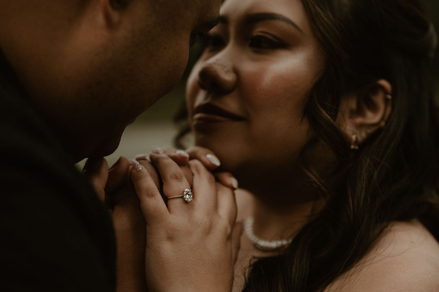 An intimate close-up of a couple sharing a tender moment with hands clasped.