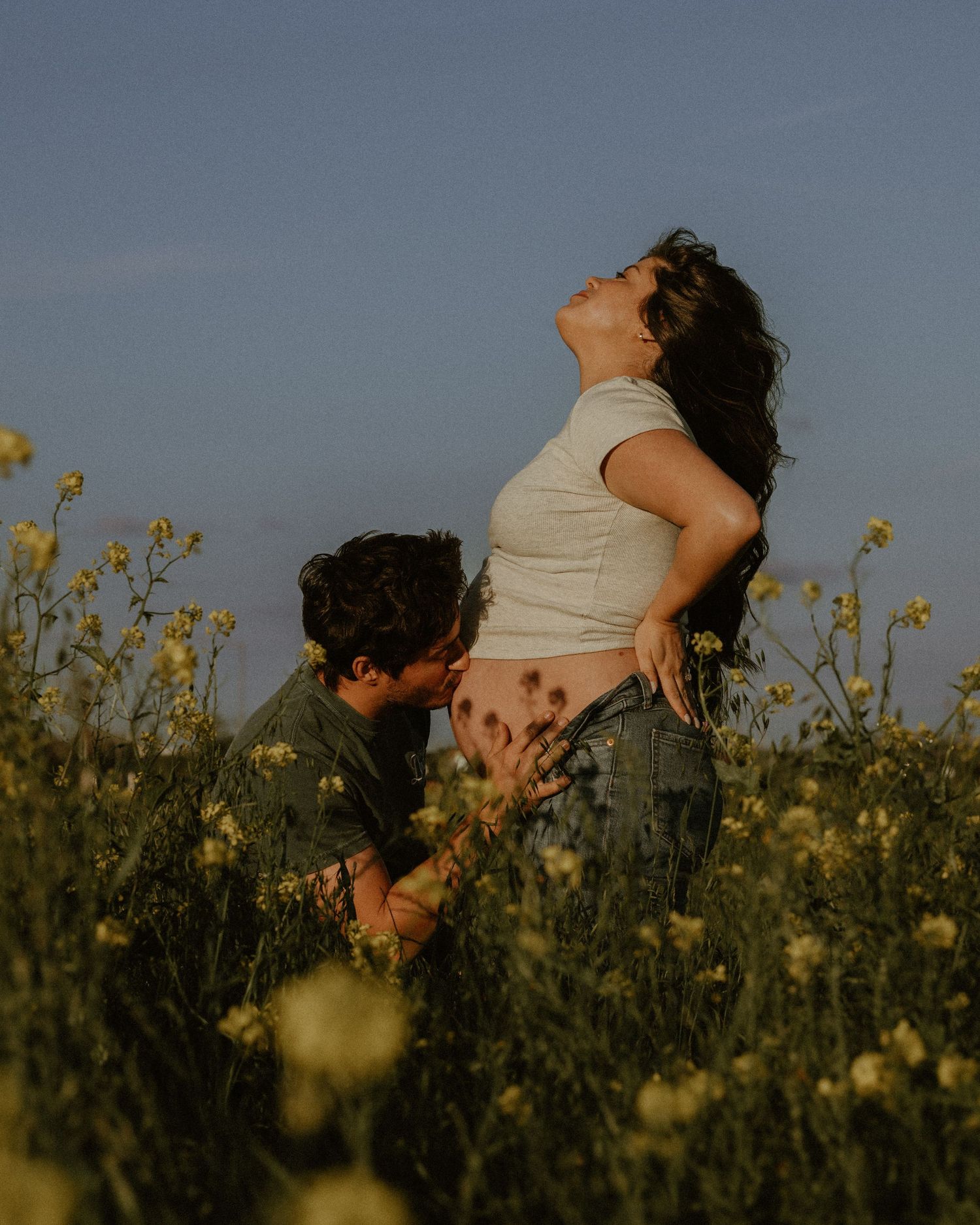 Romantic sunset photoshoot in a field of yellow wildflowers.