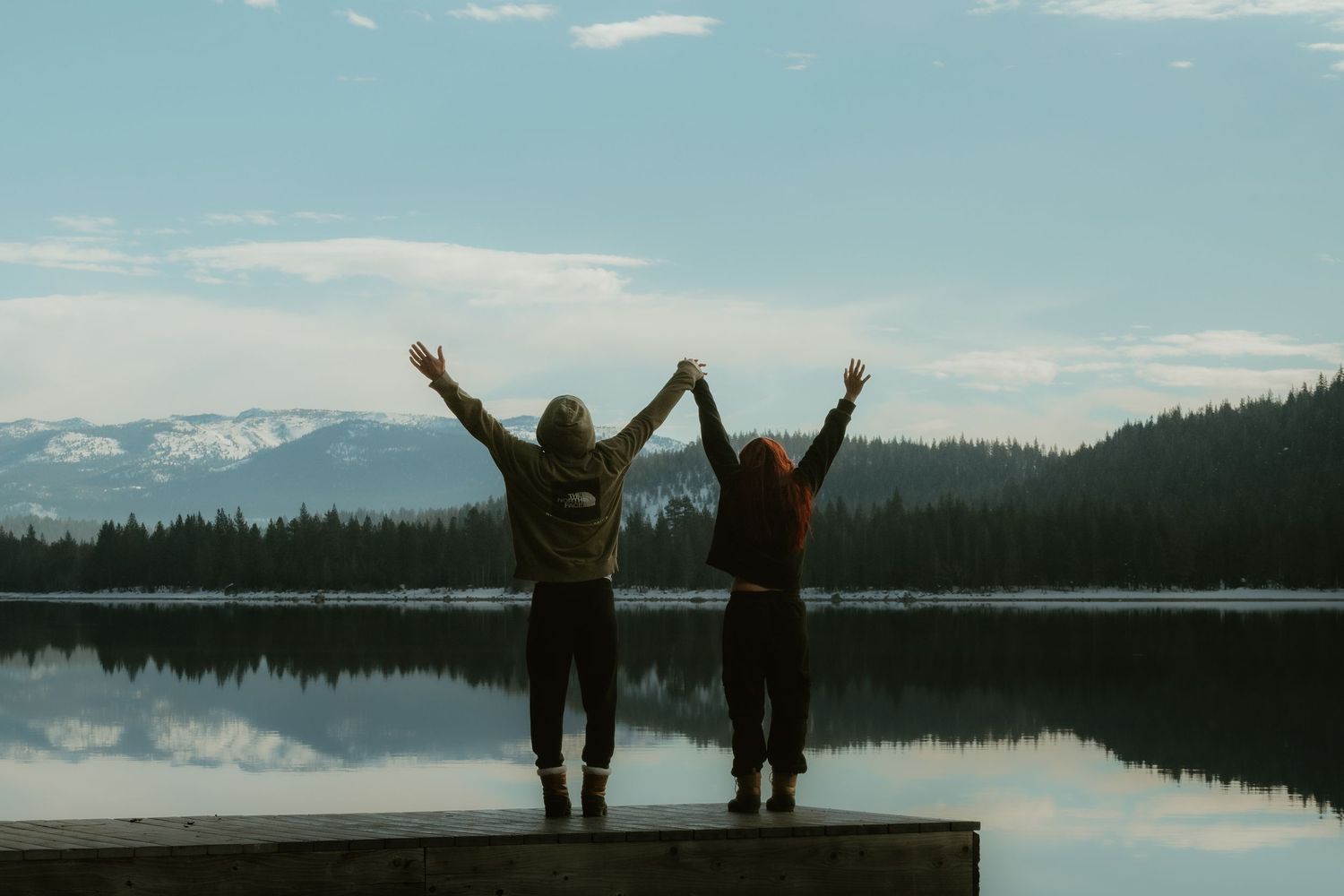 A sequence of six landscape photos shows silhouettes of people with raised arms against a serene lake and mountain backdrop.