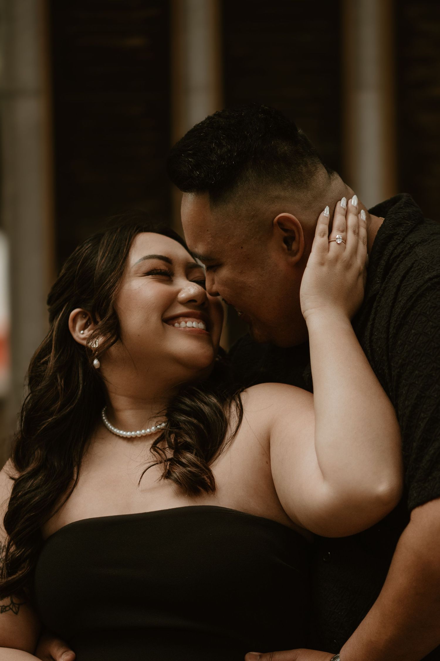 A joyful intimate moment shared between a couple in formal black attire.