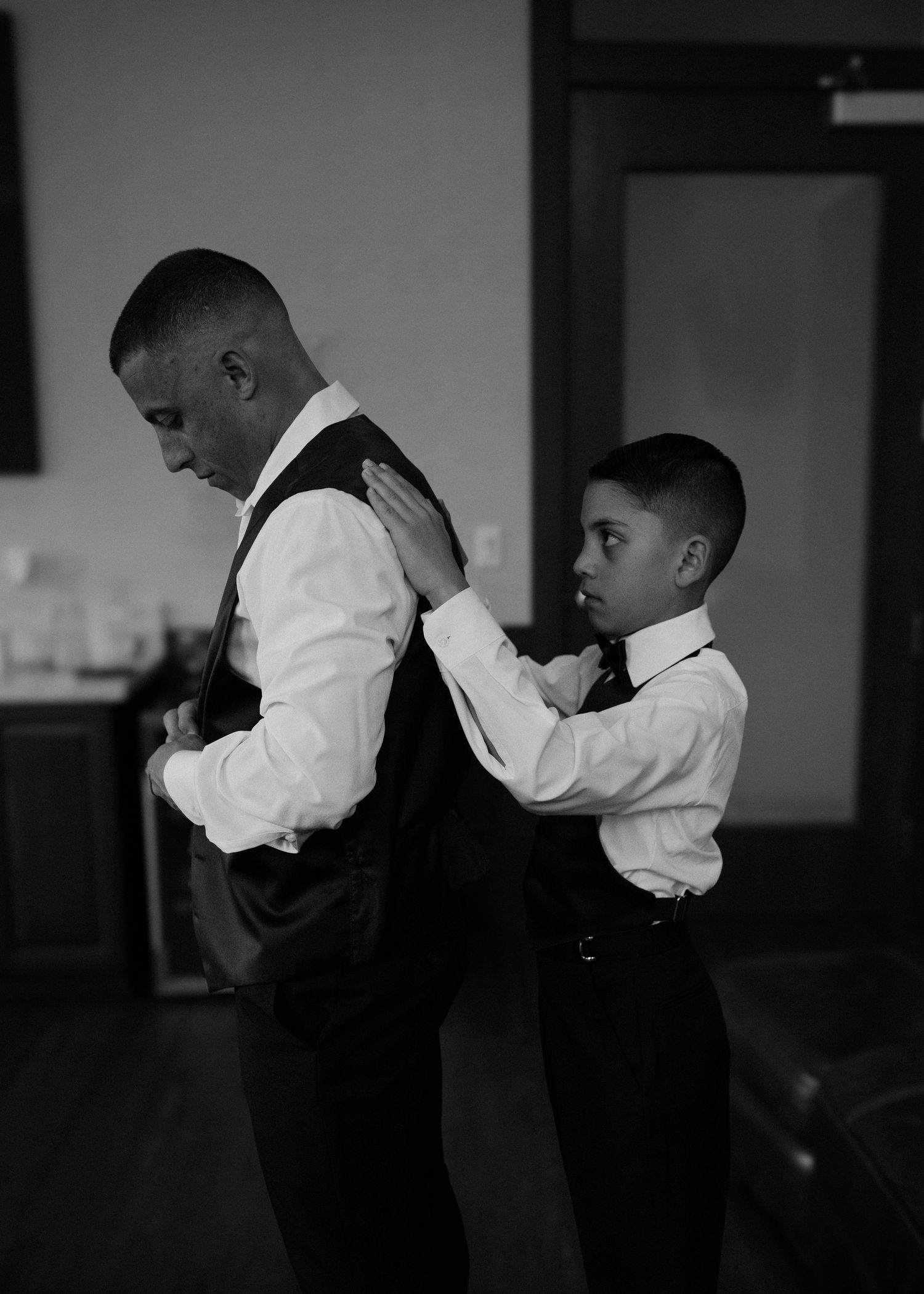 A touching moment of dress preparation before a formal event.