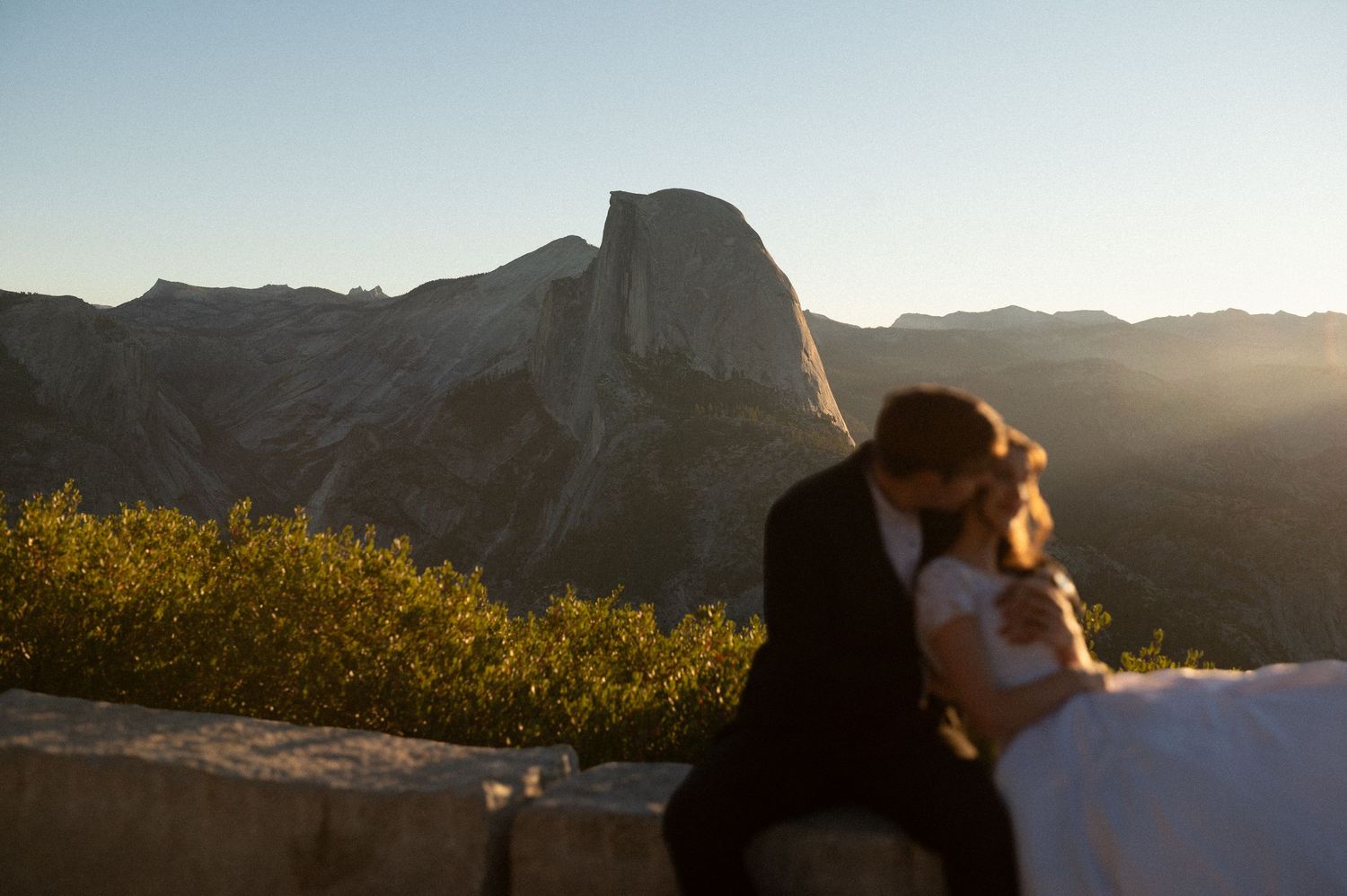 Scenic mountain vista at sunset with silhouettes in the foreground.