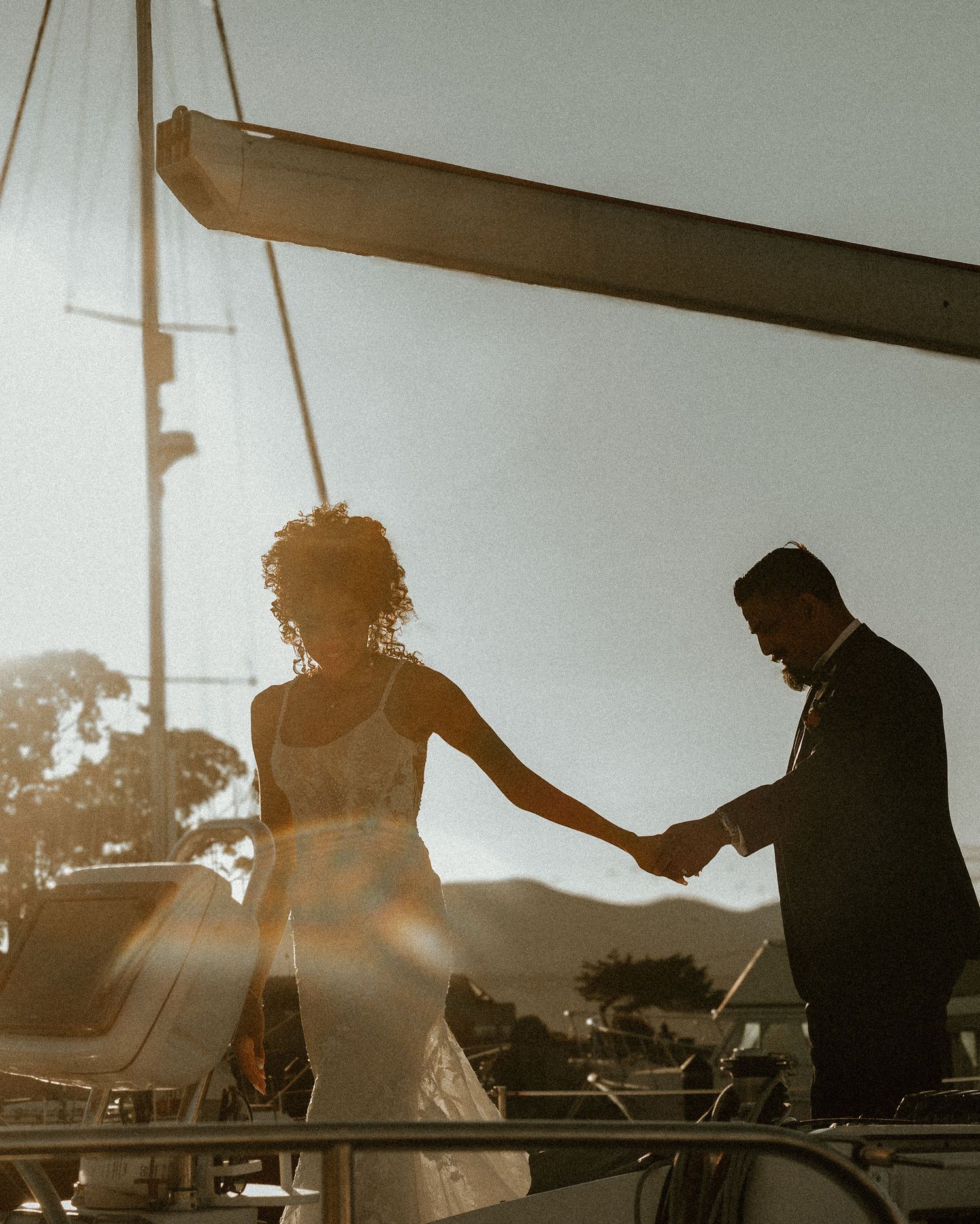 Silhouetted couple sharing a moment on a boat during golden hour.