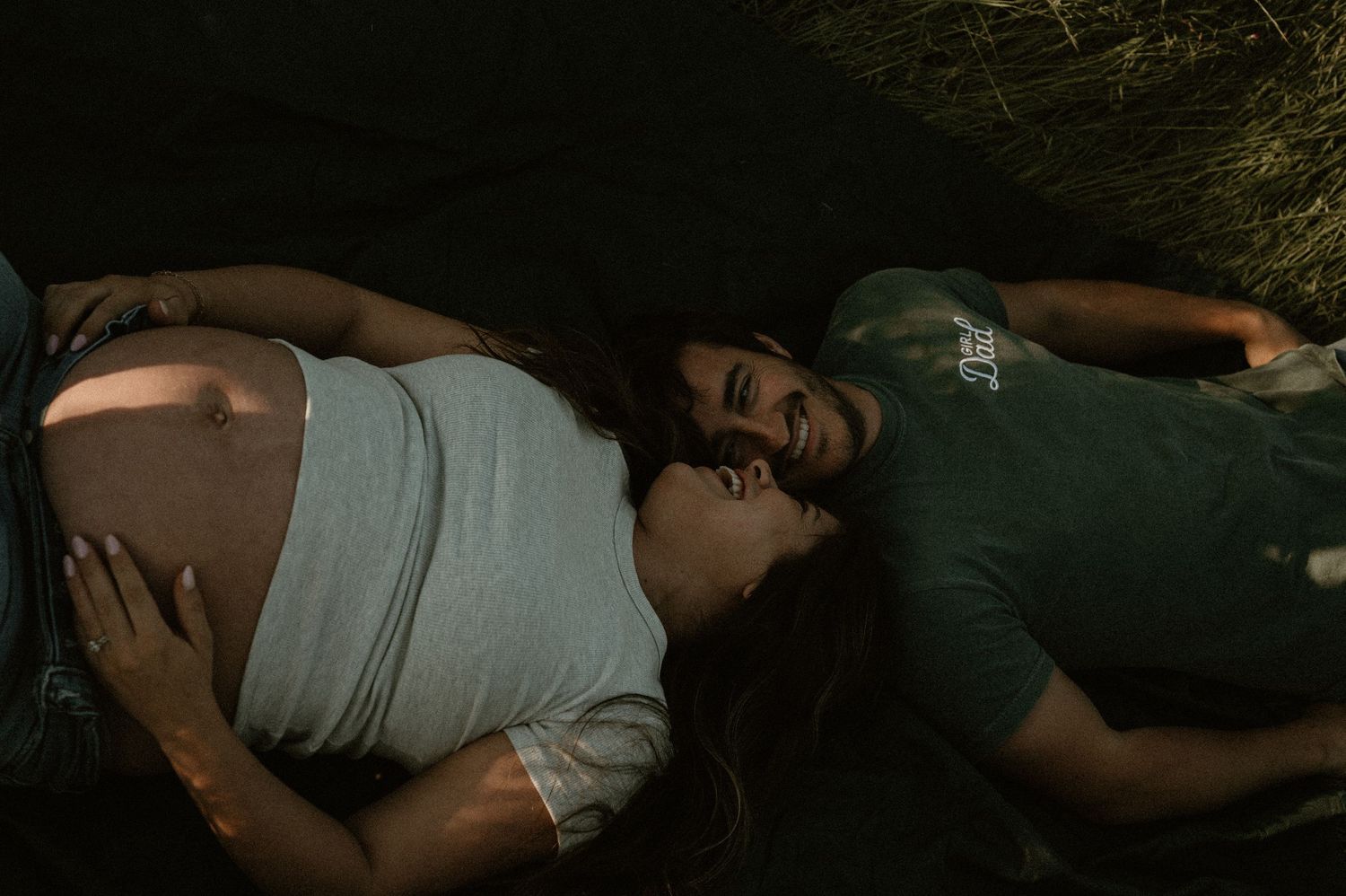 Artistic black and white photo of couple lying down during intimate photoshoot.