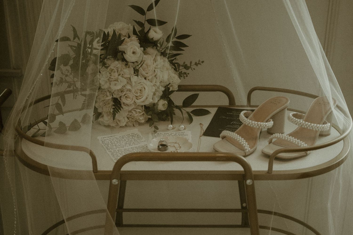 Wedding accessories including shoes and a white floral bouquet displayed on an elegant serving cart.