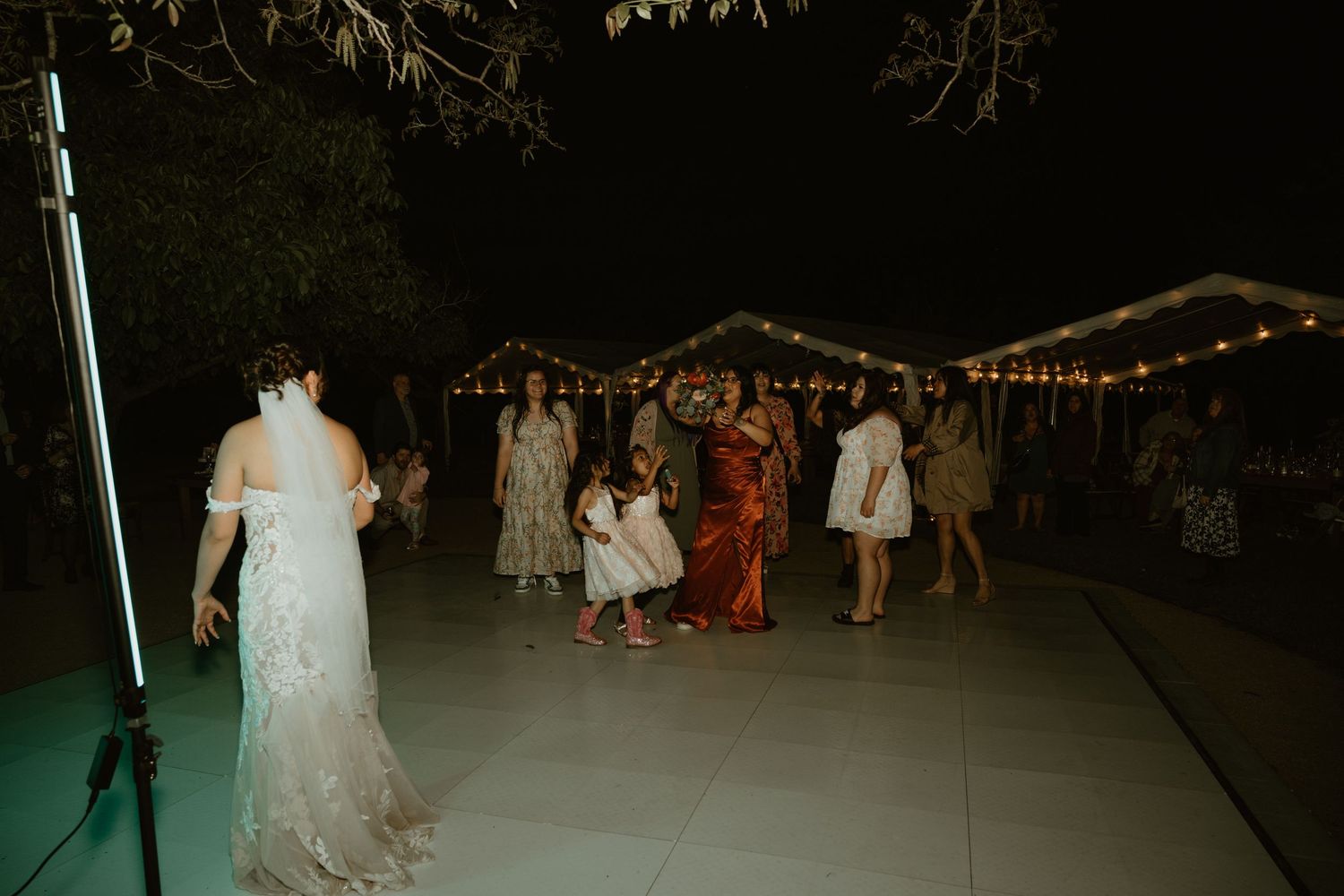 Outdoor wedding reception venue at night with string lights creating ambient atmosphere.