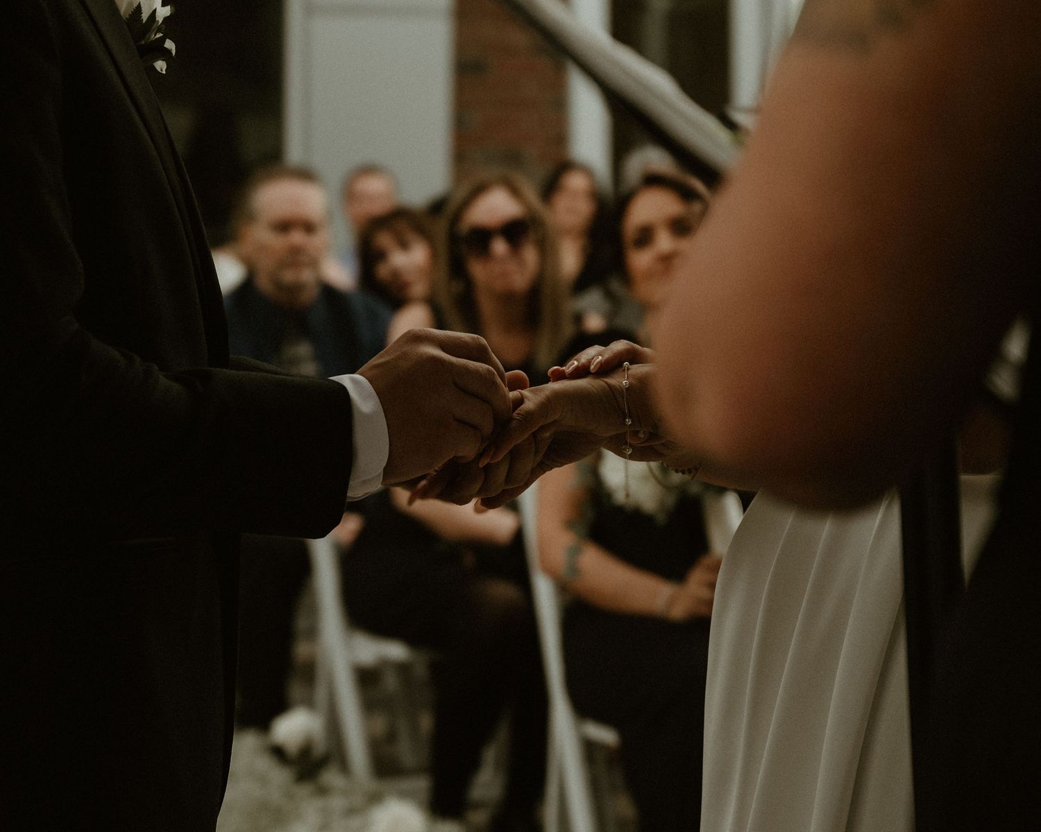 A close-up of wedding rings being exchanged during an outdoor ceremony.