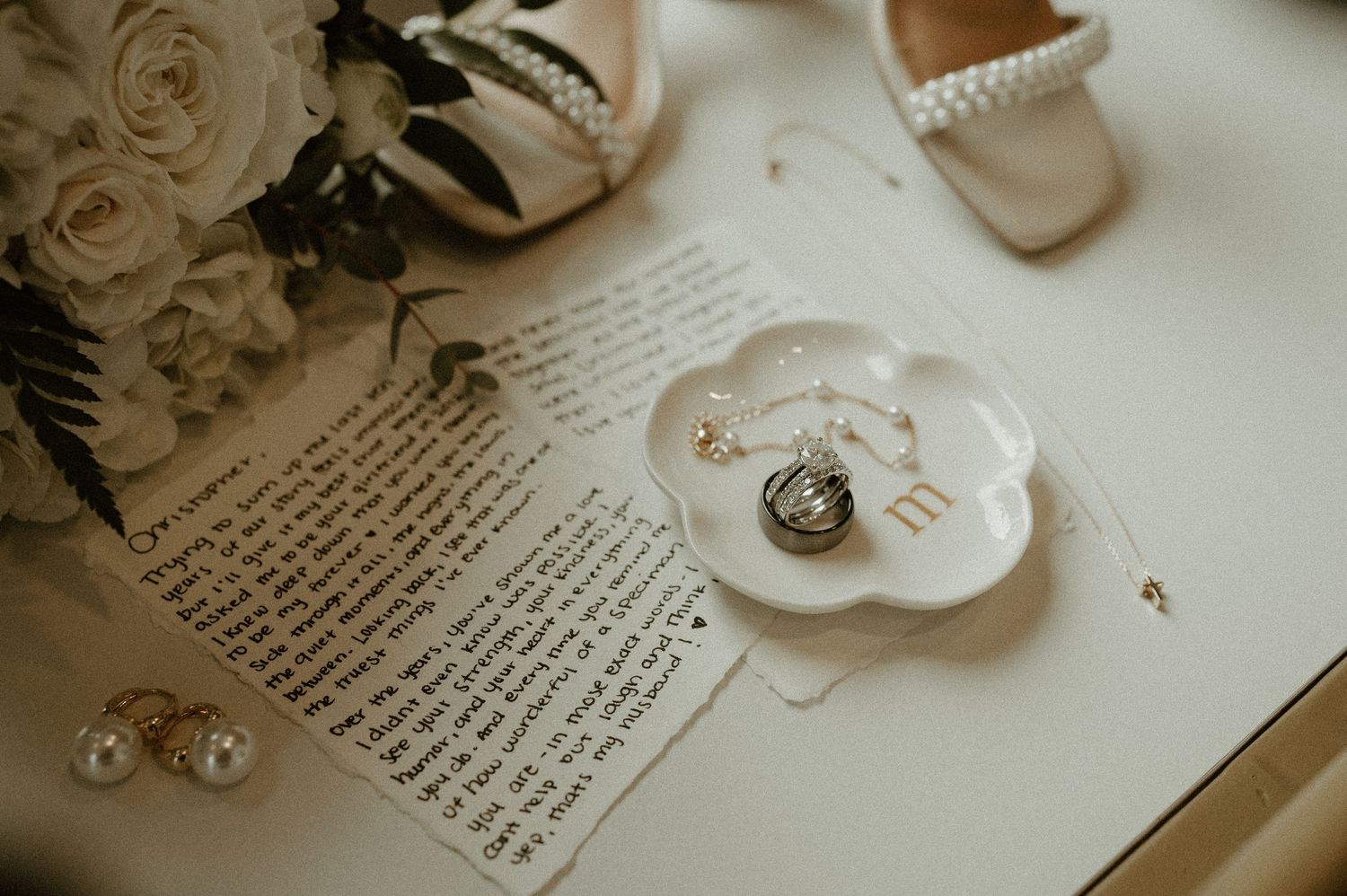 Wedding details with rings and paper elements styled in soft neutral tones.