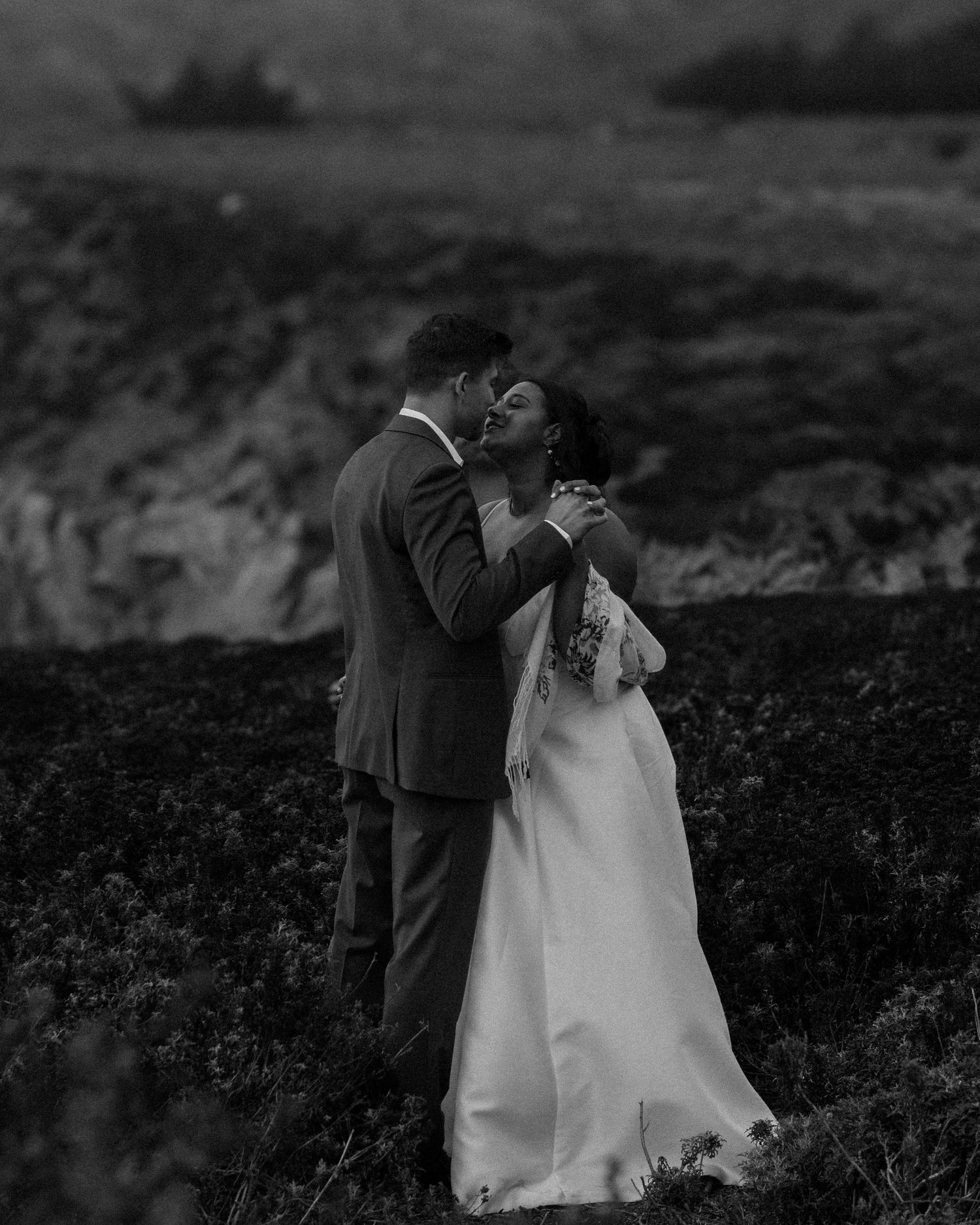 Intimate black and white wedding photos showing romantic moments in a natural setting.