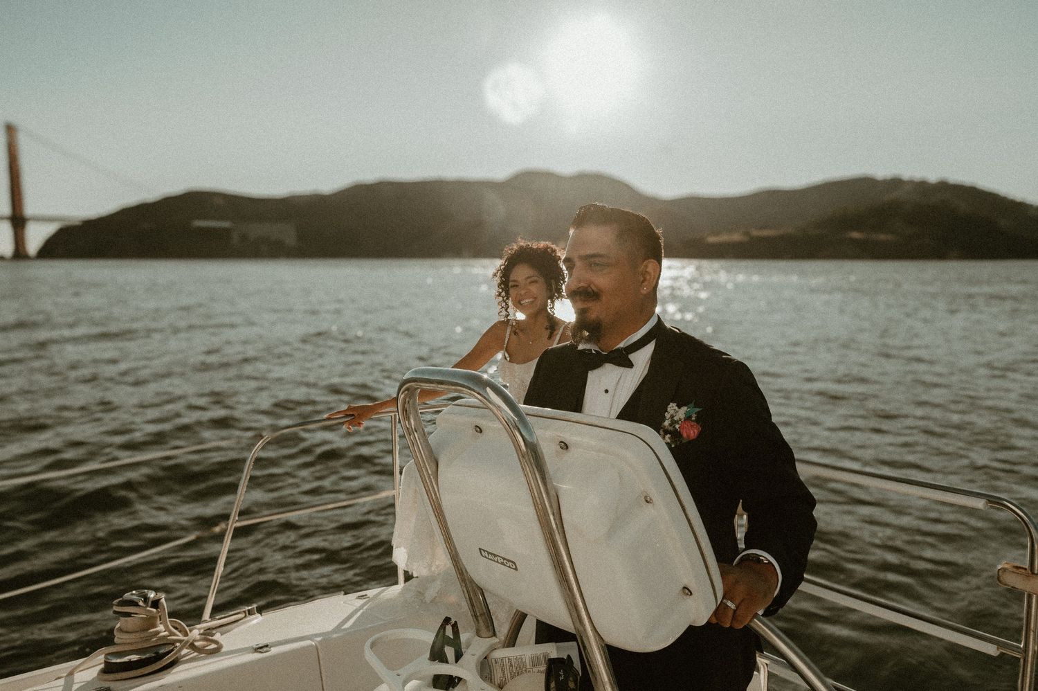 Couple enjoying a sailing adventure with the Golden Gate Bridge in the background.