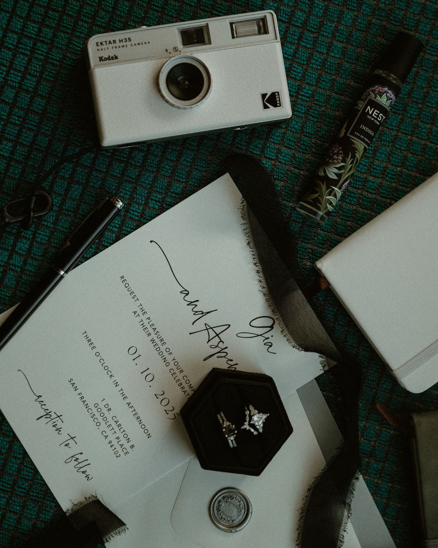 A collection of vintage film cameras and photography equipment arranged on a dark green textured surface.
