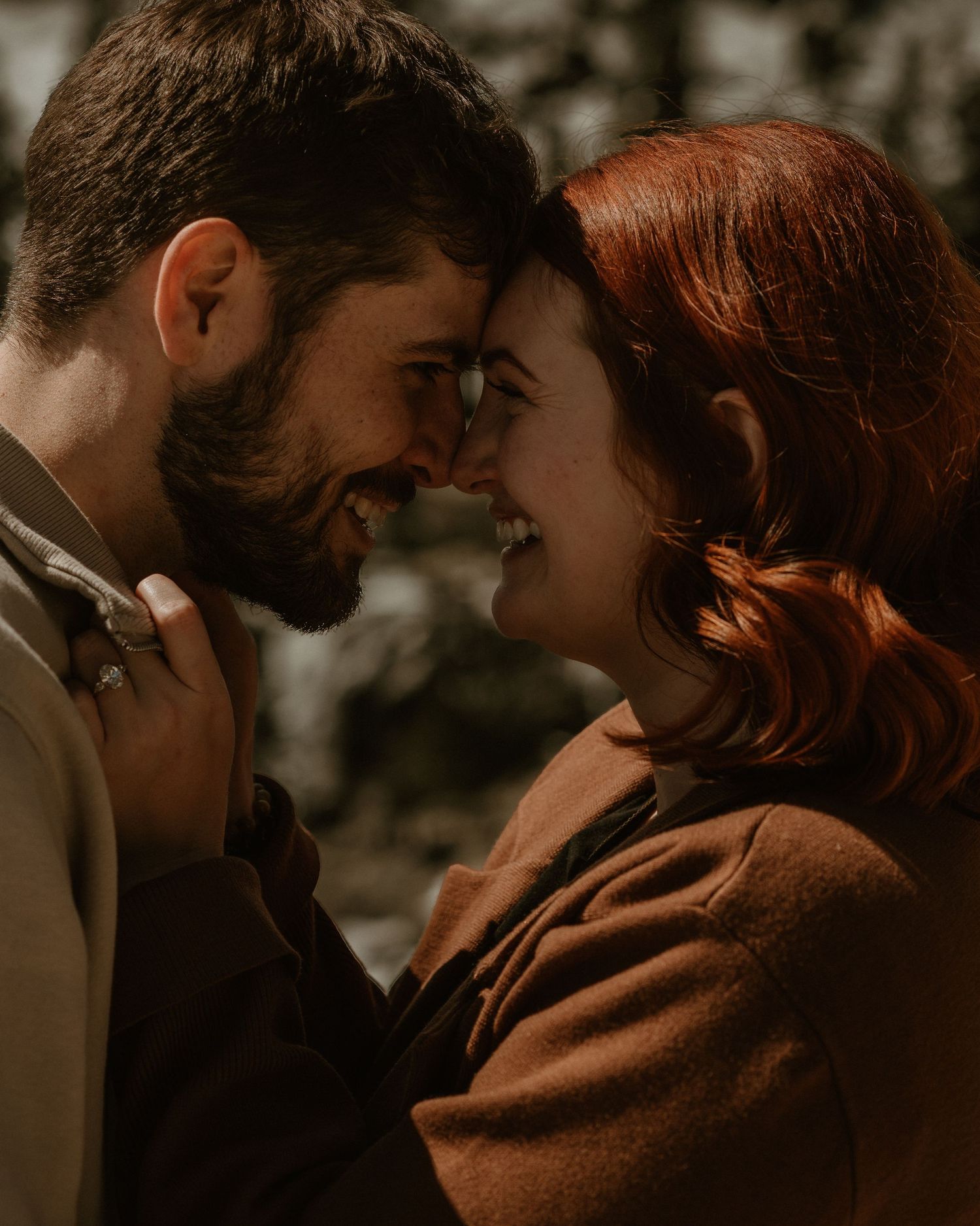 An intimate moment captured in a dark, atmospheric setting with warm brown tones.