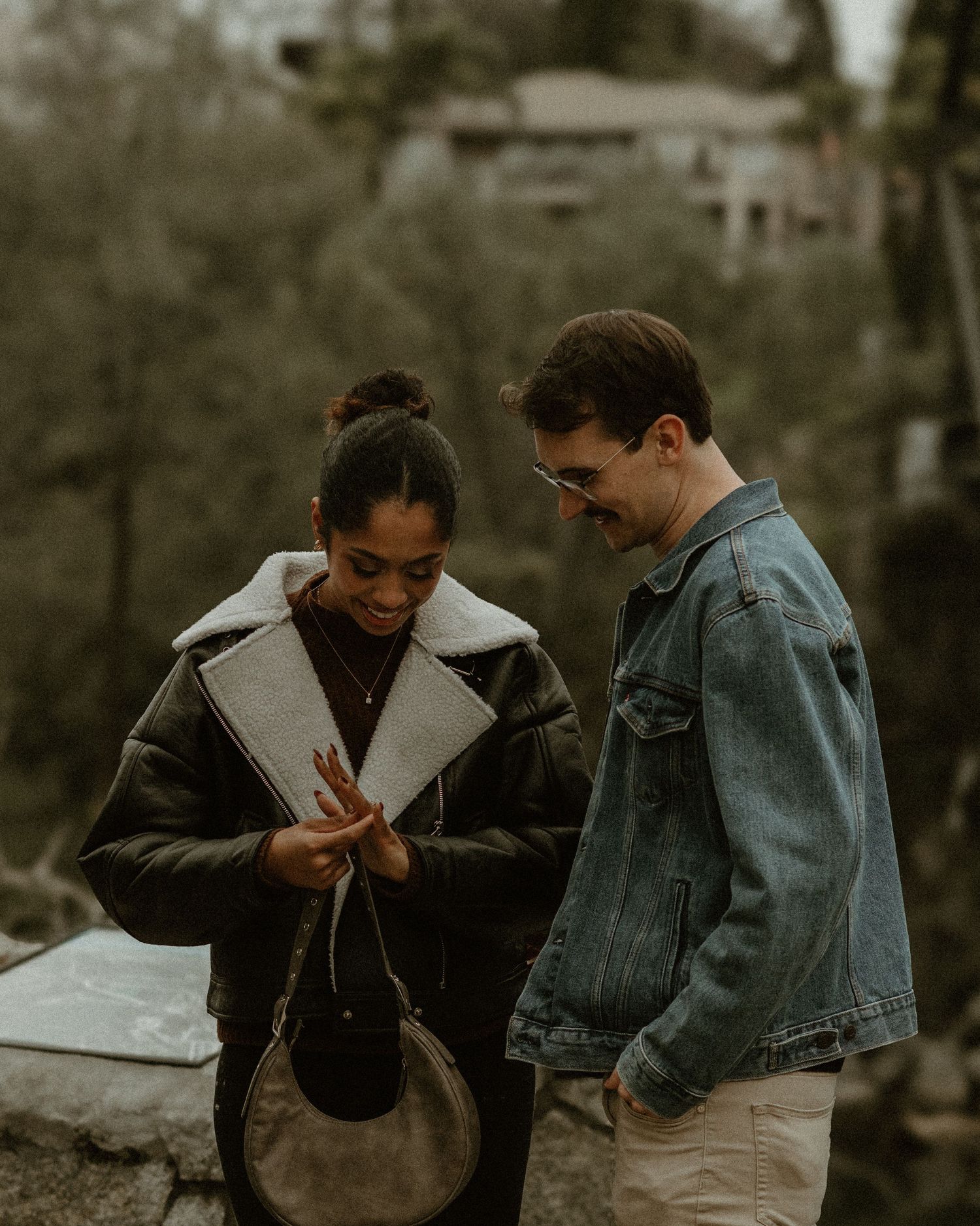 Two people share an emotional moment outdoors wearing casual denim and winter clothing.