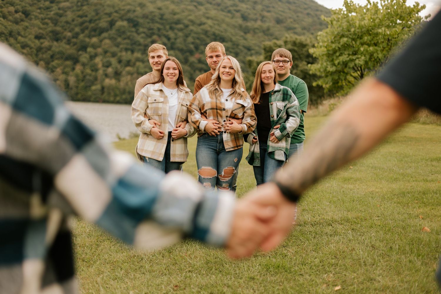 Candid moments captured outdoors on a grassy hilltop during golden hour.