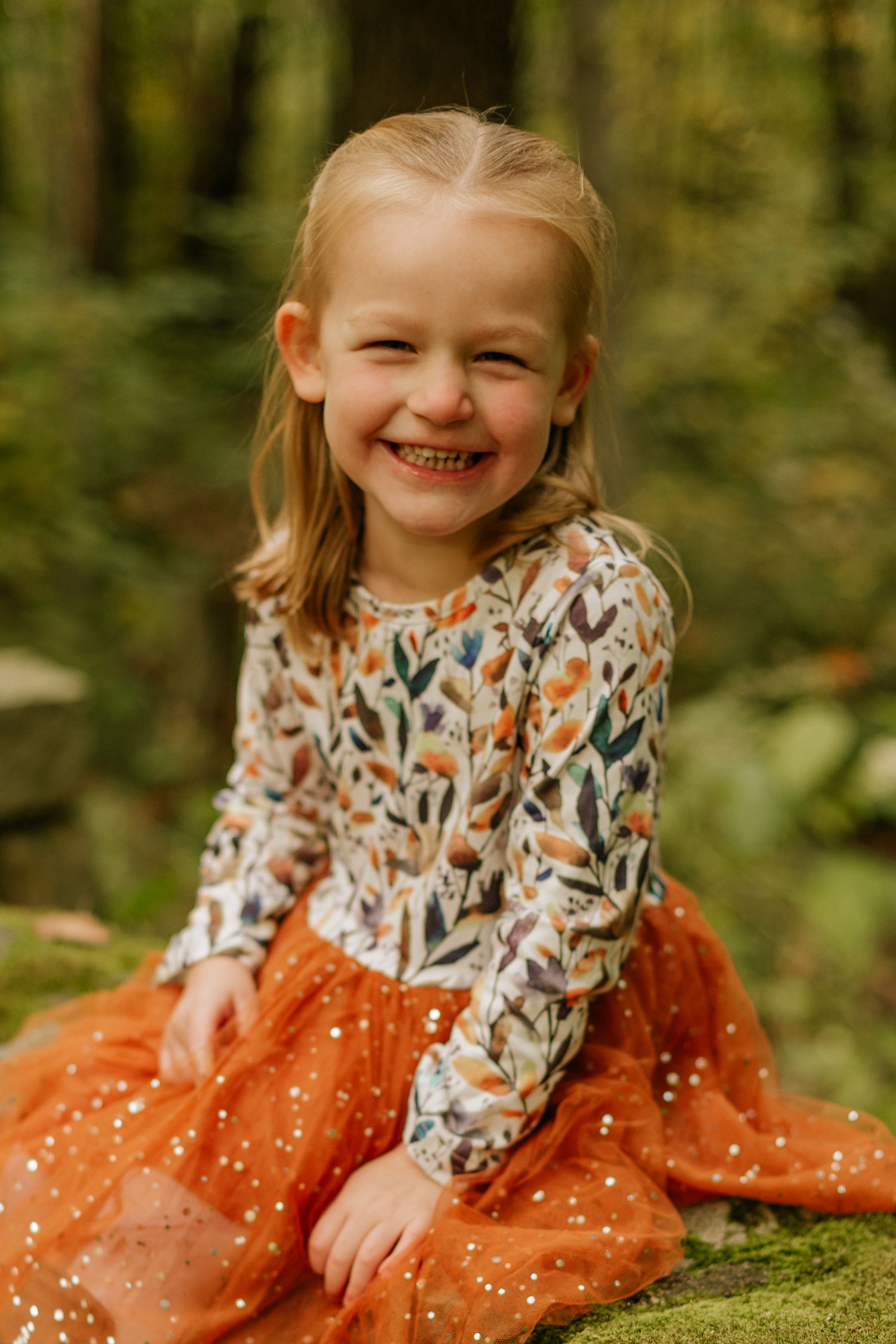 Whimsical forest photoshoot featuring an orange polka dot dress and floral print top.