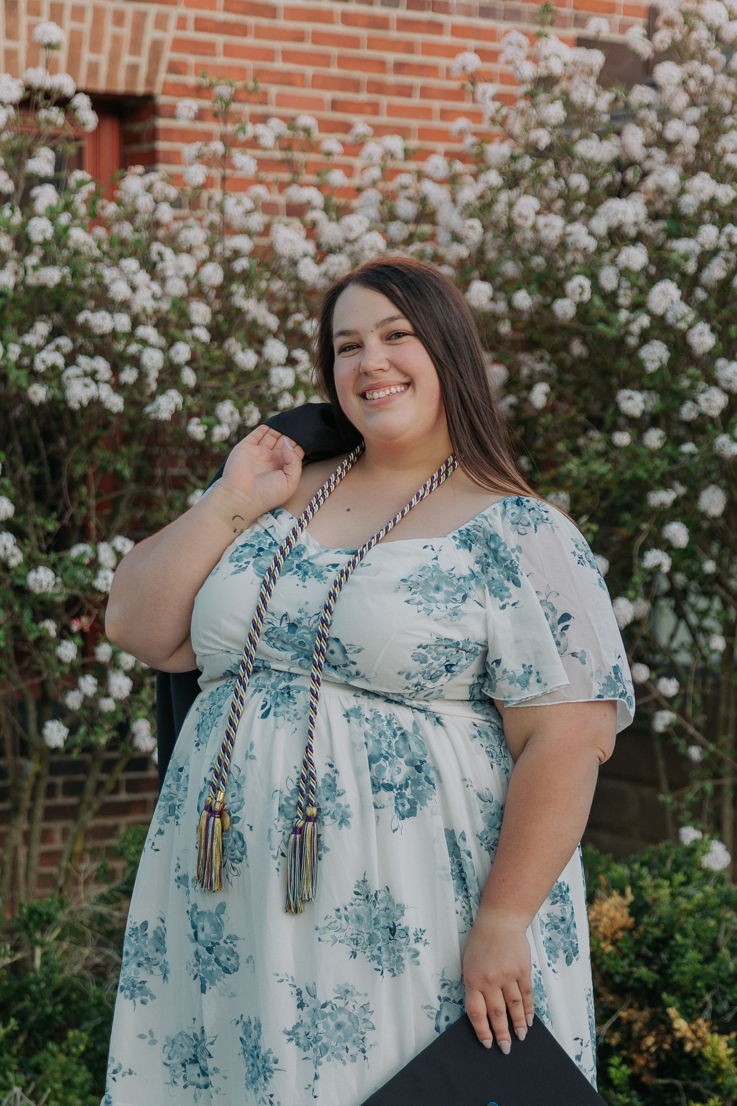 Beautiful floral spring portraits against a brick wall with white roses.