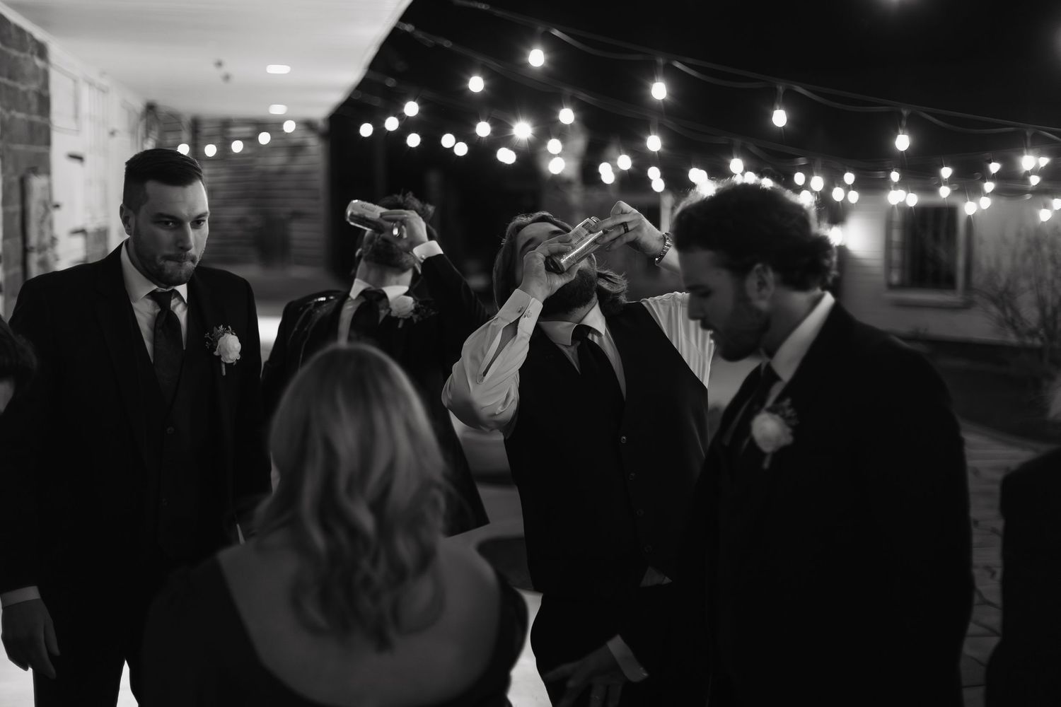 A black and white photo series shows wedding guests dancing and celebrating at an evening reception.