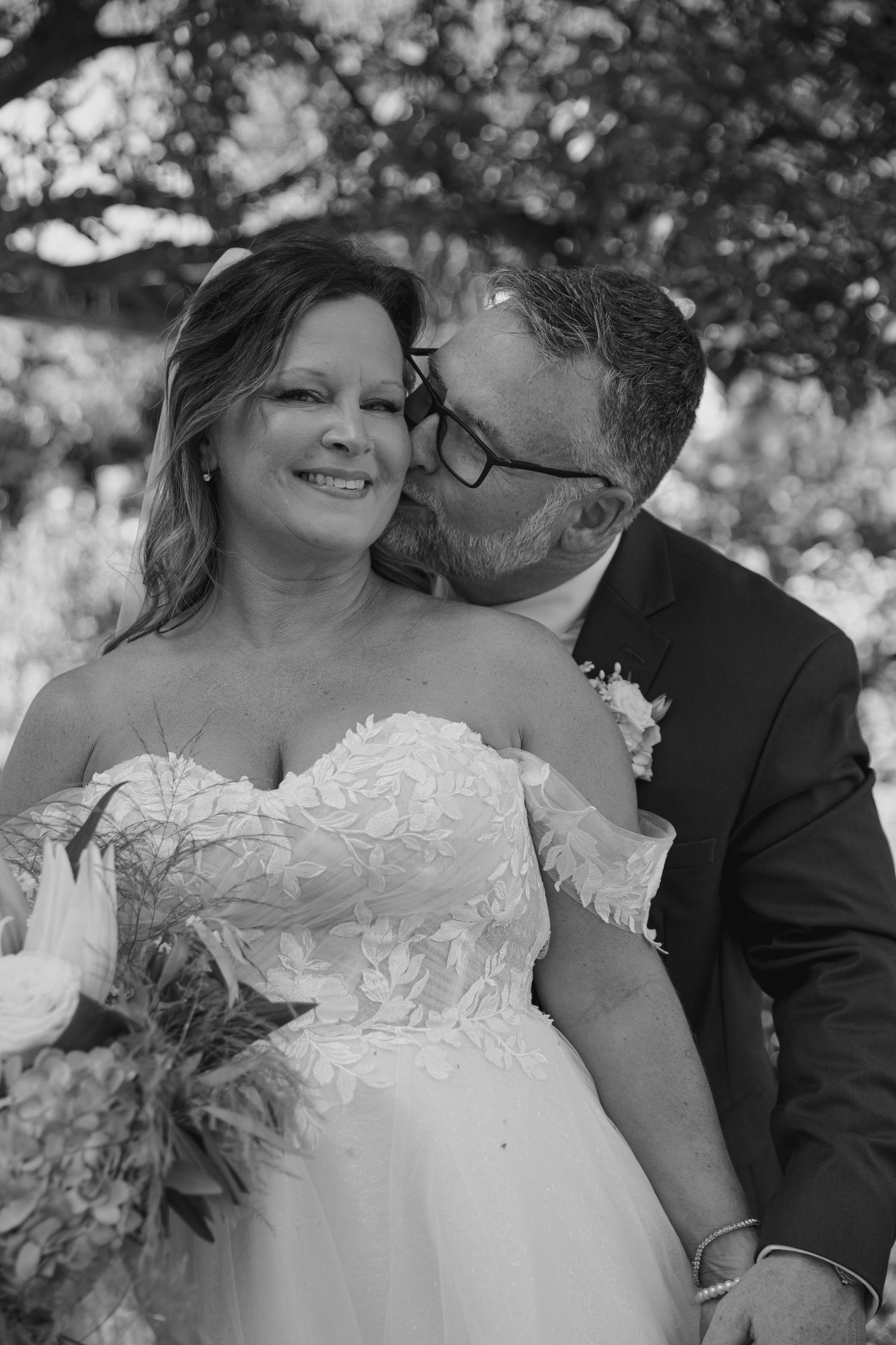Romantic black and white portrait of a couple sharing an intimate moment on their wedding day.