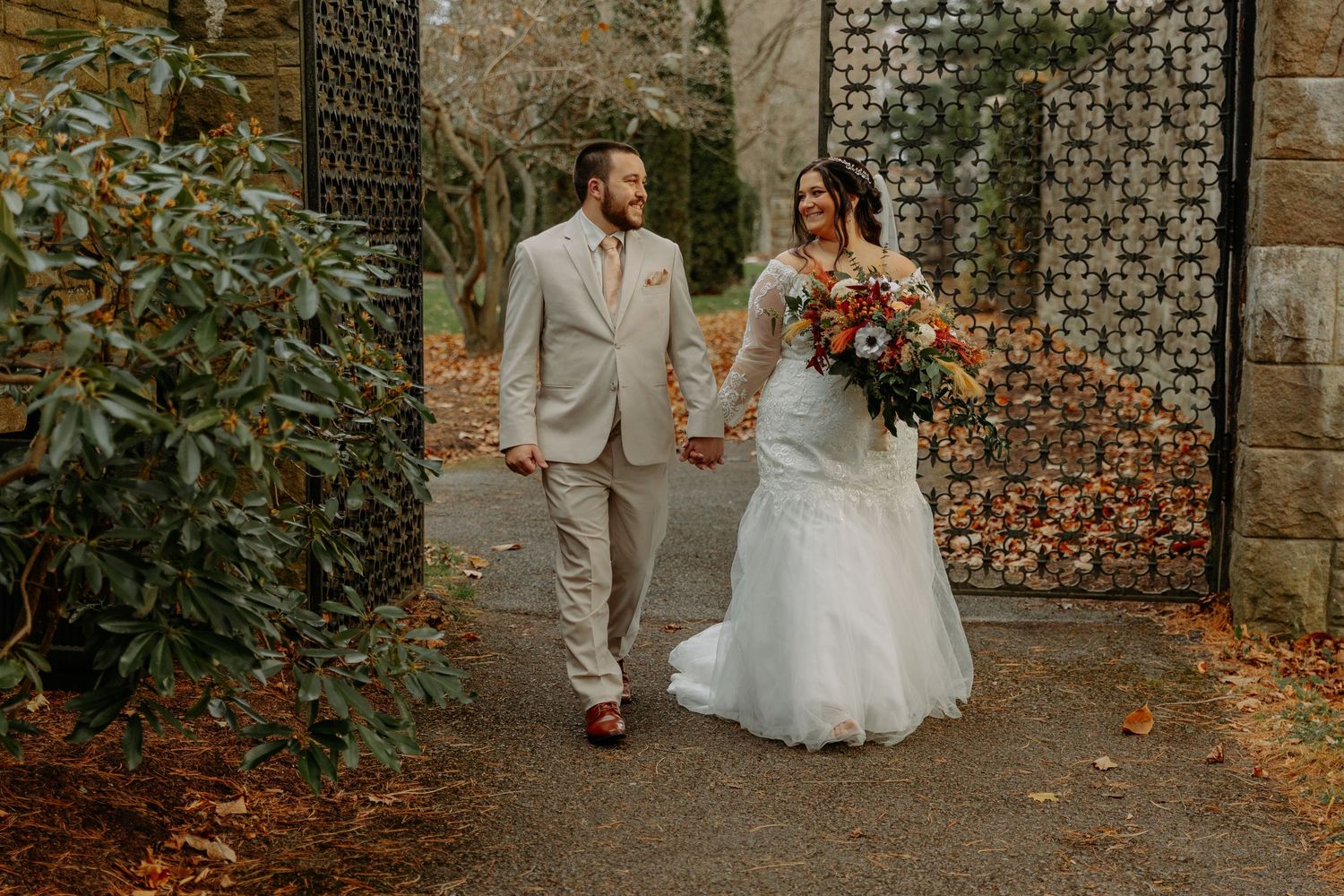 Elegant wedding photos taken against vintage stone walls with decorative ironwork.