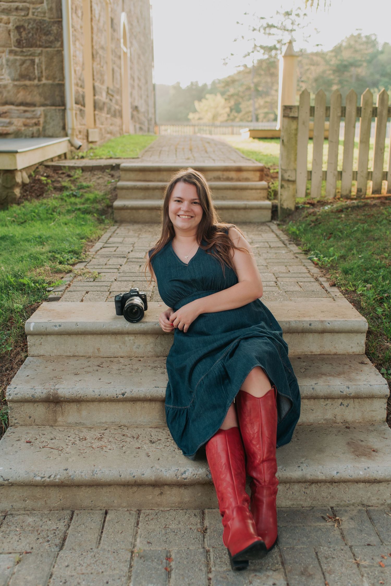 Navy dress and red boots complemented by rustic stone steps and garden setting.